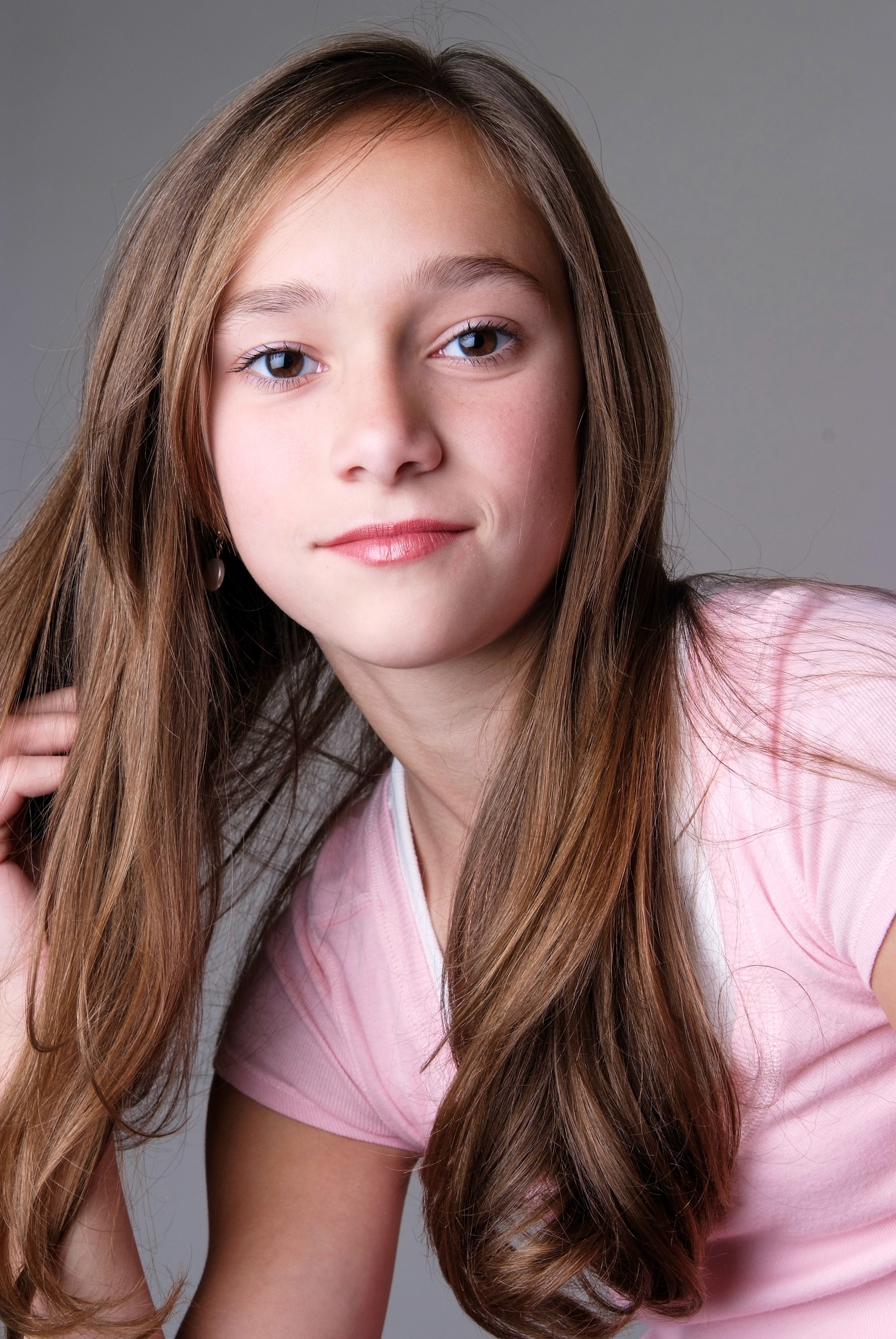 your famle actor in pink top with brown hiar on a gray backdrop headshot