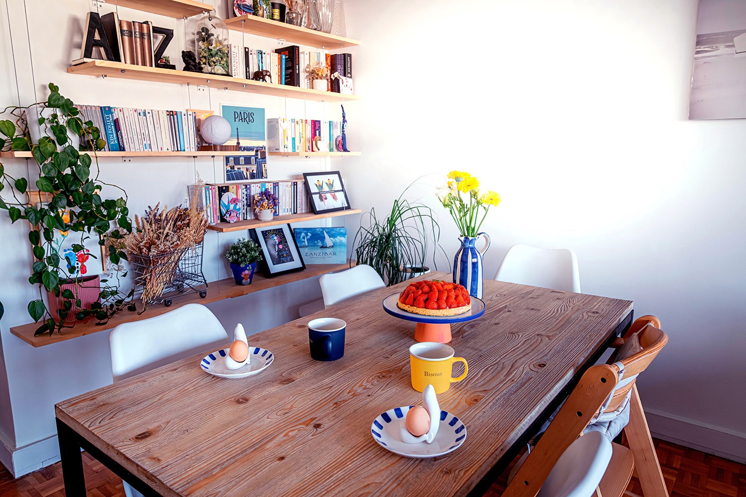 Table à manger bois avec décoration naturelle et étagères murales design.