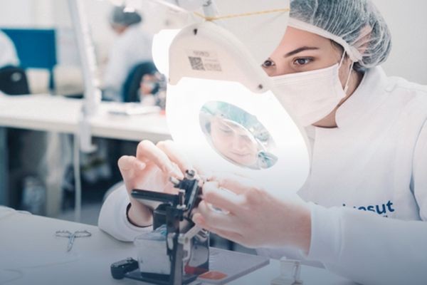 Colaboradora em processo de produção de sutura cirúrgica