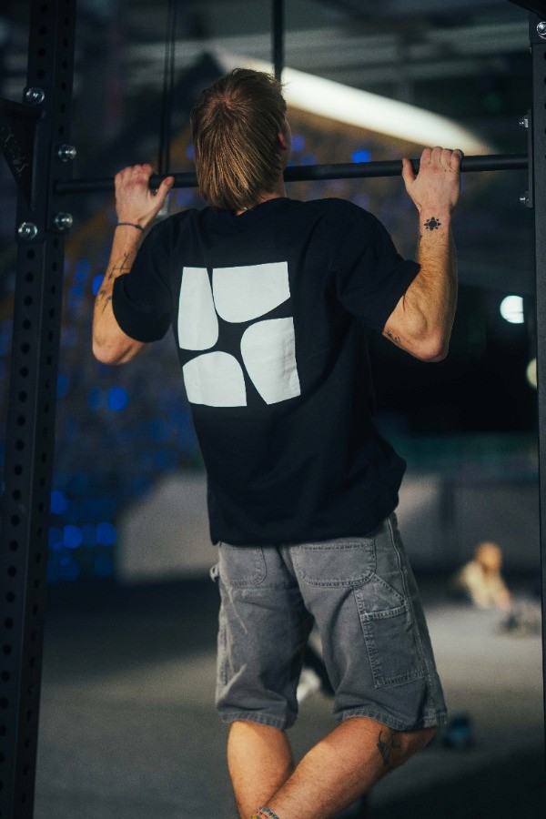Athlet trainiert Klimmzüge im Indoor Functional Fitness Bereich – Krafttraining zur Unterstützung von Bouldern und Klettern.
