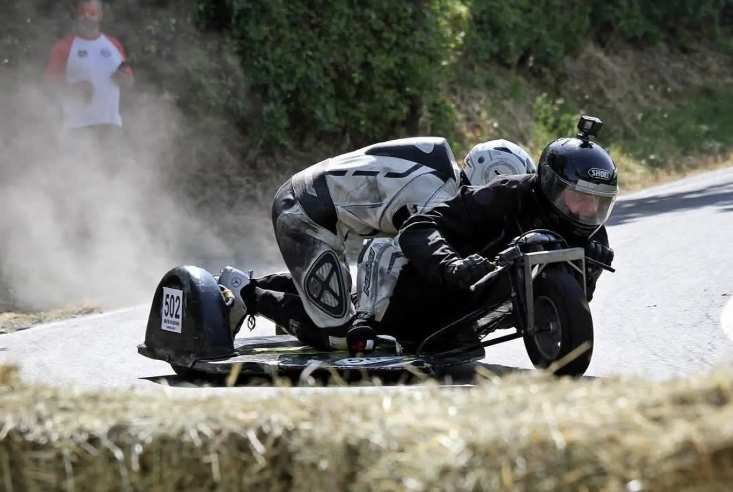 Side-car en dérapage spectaculaire avec poussière et bottes de paille