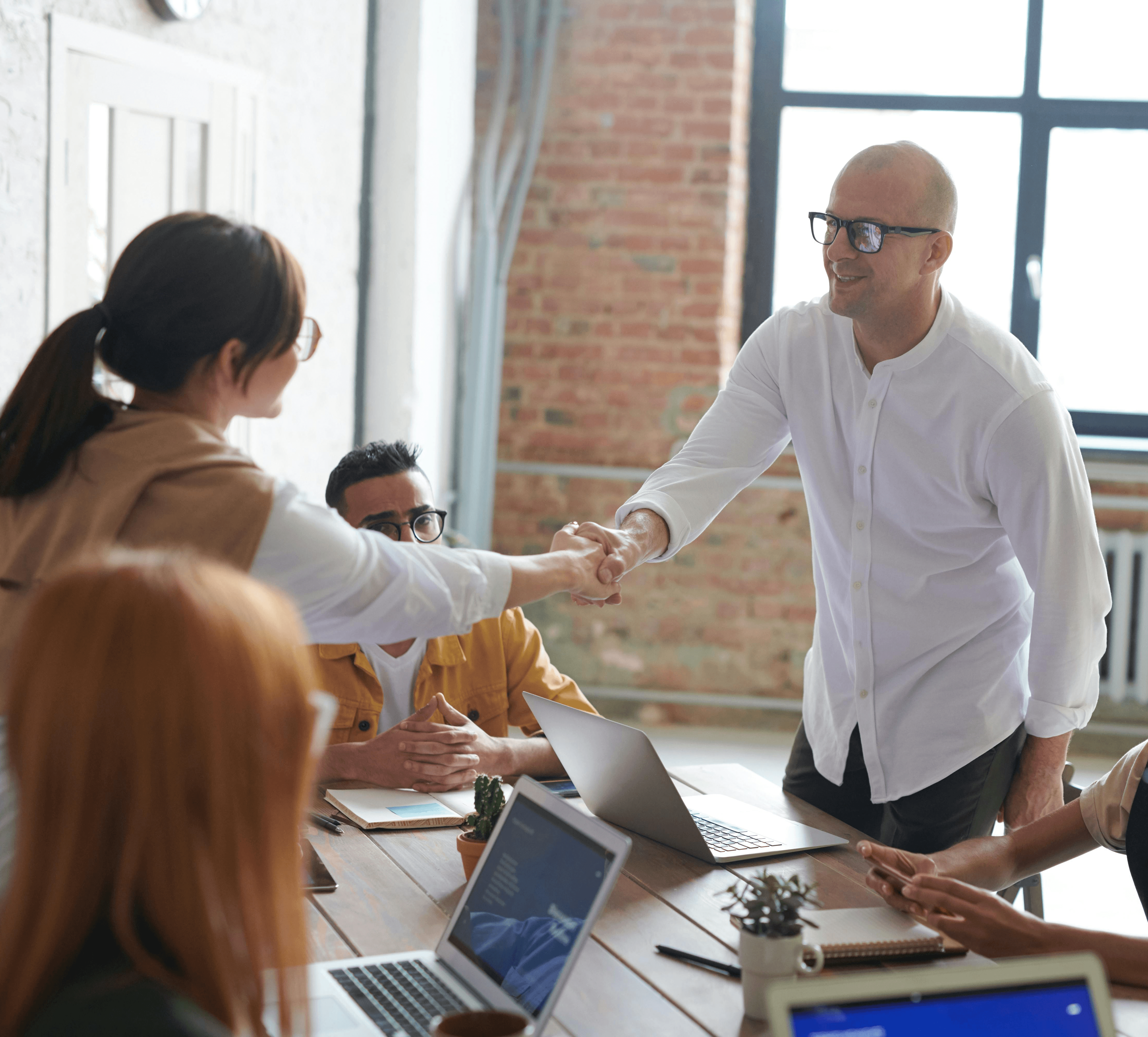 Professionals shaking hands in a modern office, symbolizing a successful job offer and career growth.