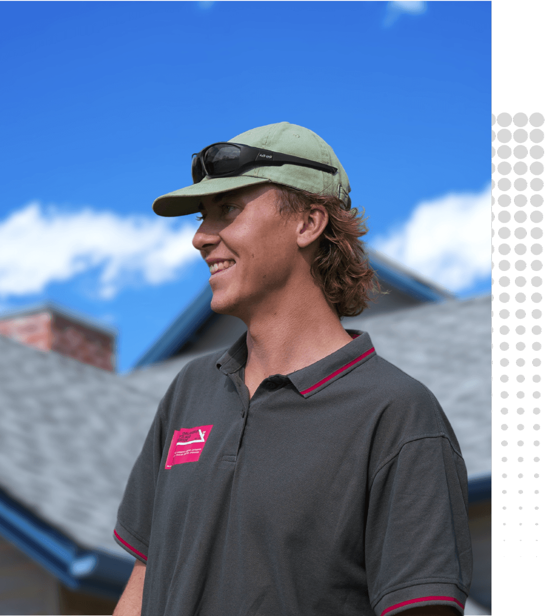 Ricky Javsnik, Founder of Queensland Quality Roofing in Brisbane, smiling while standing outdoors in front of a residential roof under a bright blue sky. A trusted roofing expert dedicated to high-quality craftsmanship and customer service.