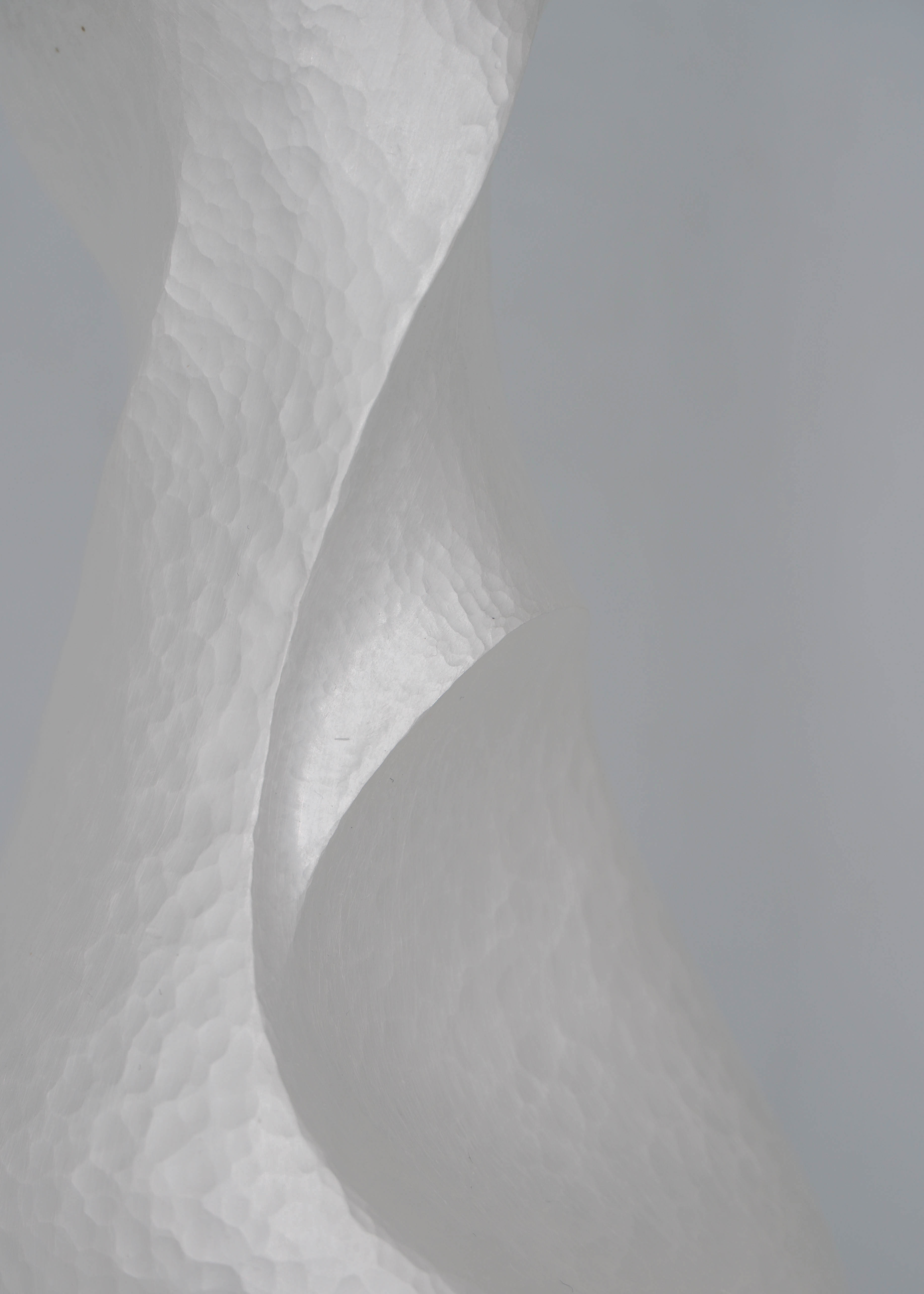 Close-up of Constrict by Yuxin Song, hand-forged fine silver vase. Contemporary silversmithing and metalwork by artist Yuxin Song