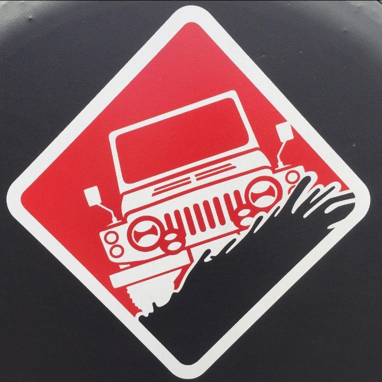 A young man with light brown hair is wearing a black suit jacket and white shirt, standing in a softly lit office setting, conveying professionalism.