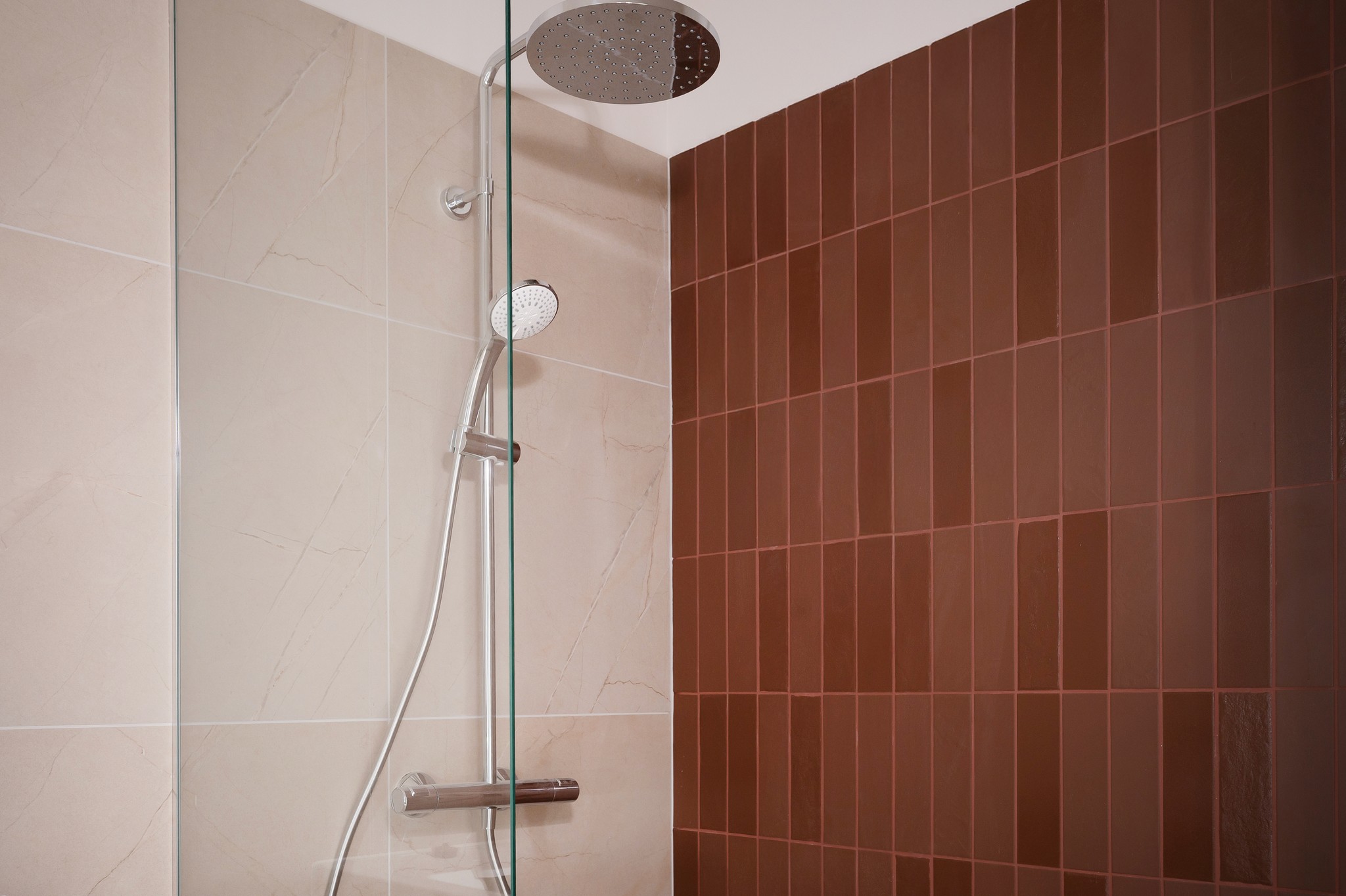 Minimalist white coastal architecture featuring modern two-story villas with wooden accents, green lawn, and palm trees under a bright sky.