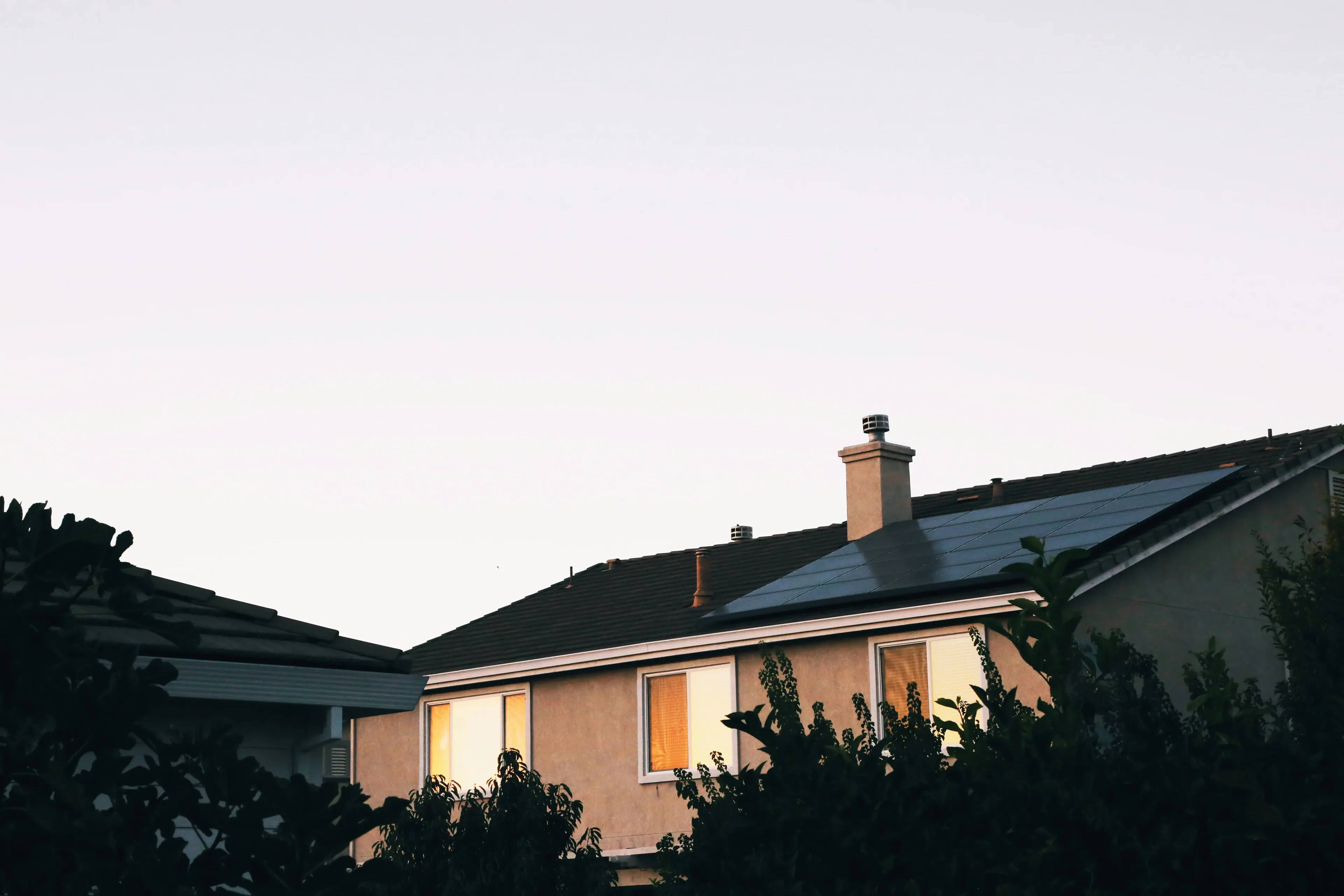 Modern home with rooftop solar panels generating clean energy at sunset