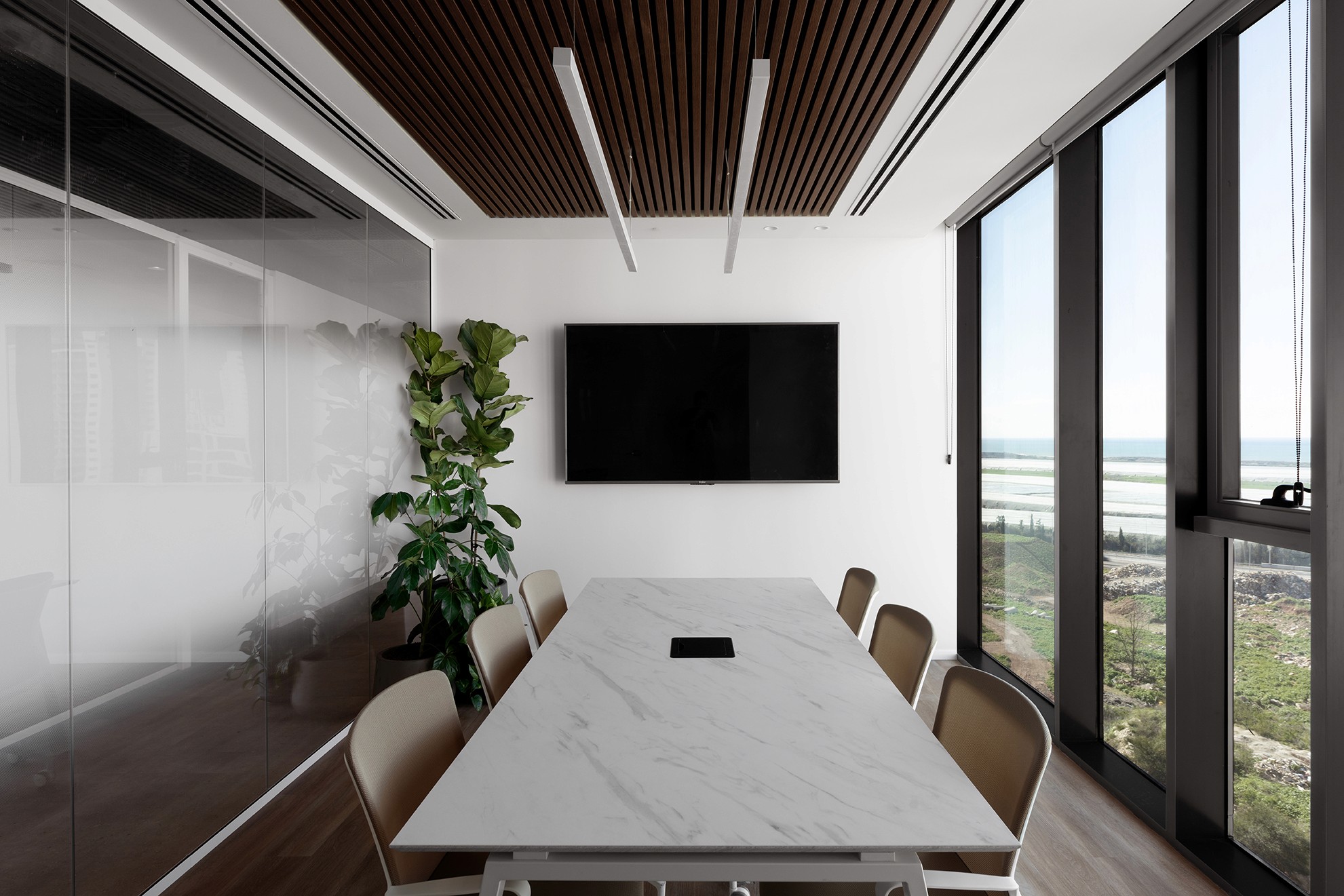 אינטגרציה של מערכות מולטימדיה: קיר כוח מעוצב המסתיר את תשתיות המסך, כחלק מעיצוב פנים נקי ומינימליסטי לחדרי ישיבות