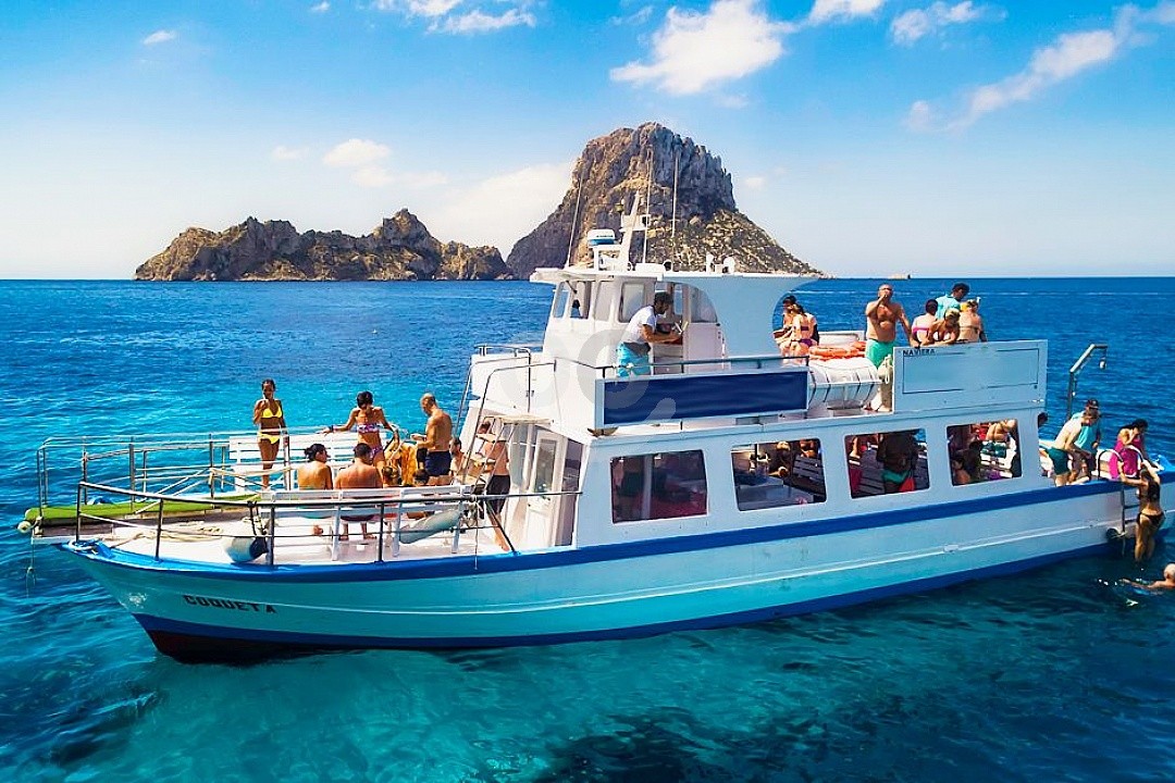 person in orange jacket standing on brown rock near snow covered mountain during daytime