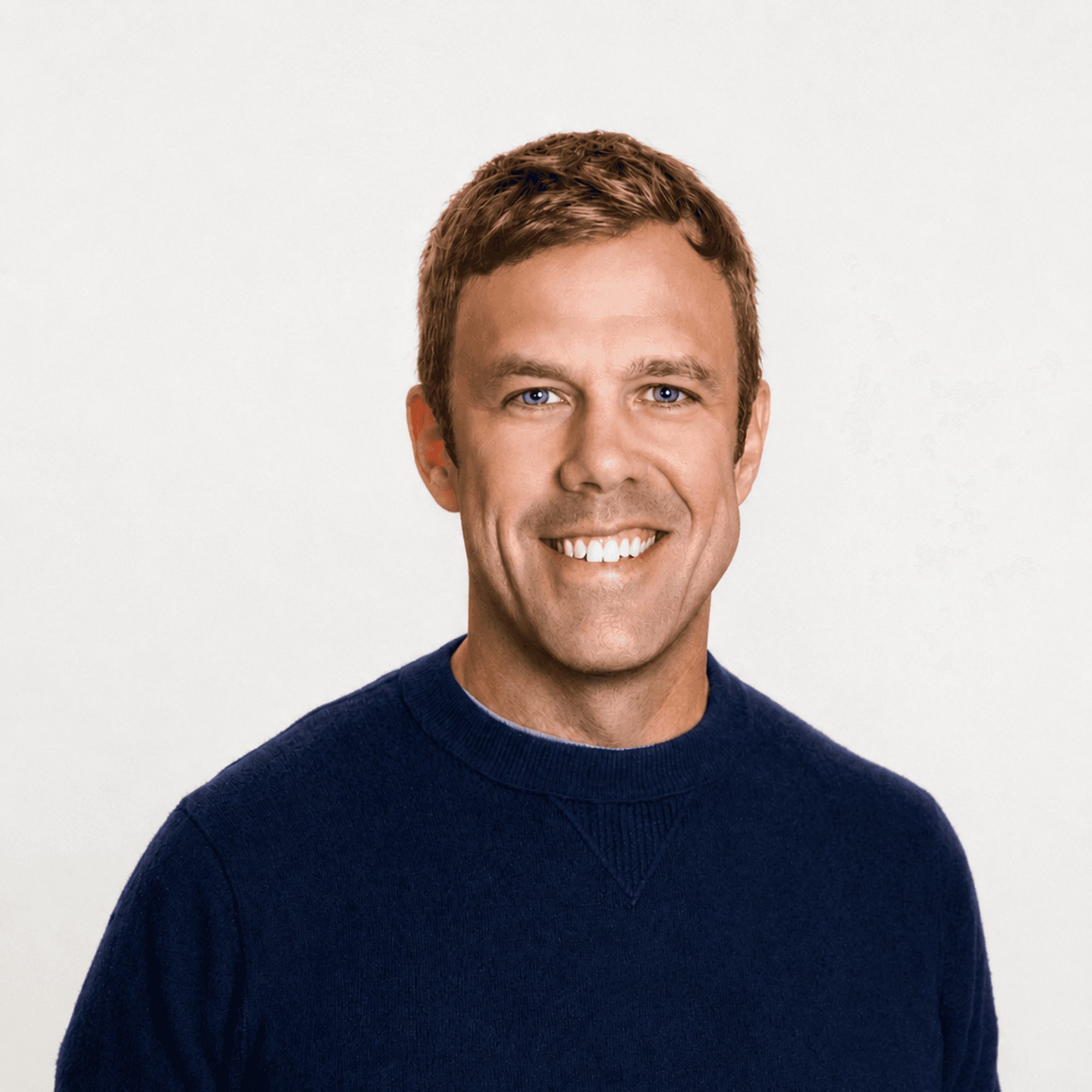 Professional headshot of a MelodyArc team member, a smiling man with short brown hair in a blue sweater.