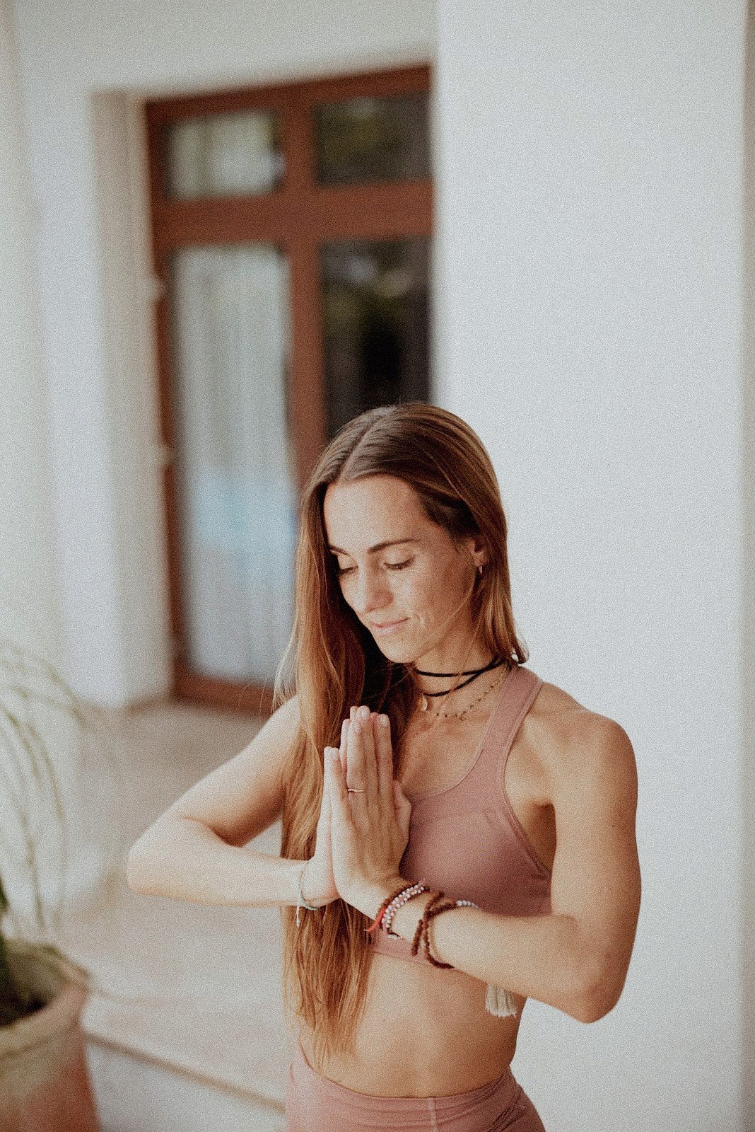Mujer en postura de meditación, enfocada en respiración y relajación para reducir el estrés.