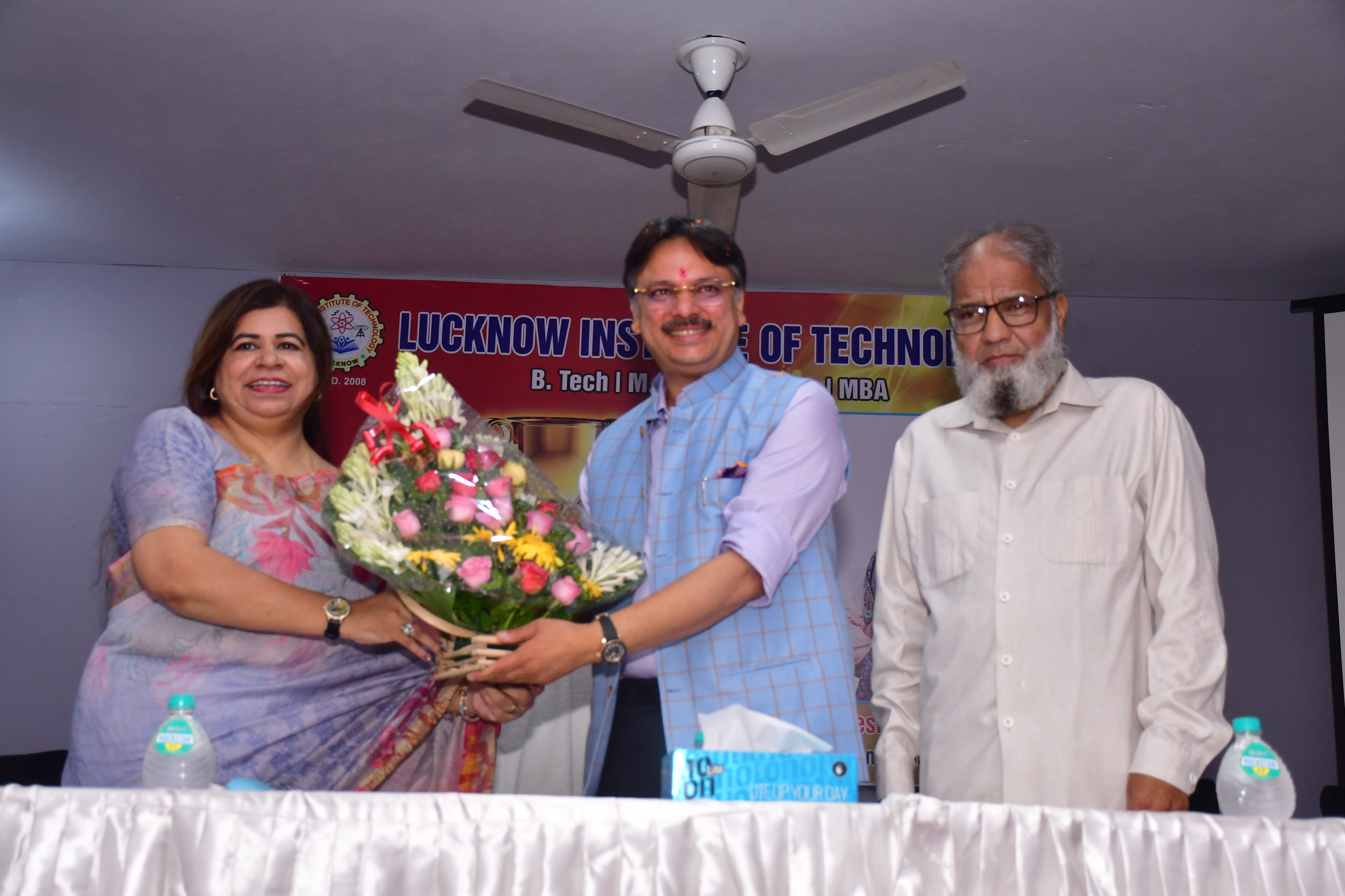 man standing in front of people sitting beside table with laptop computers