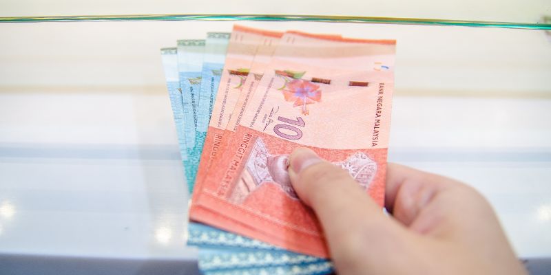 A Malaysian business owner paying with cash