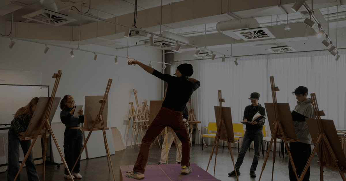 Modèle posant pour un cours de dessin, entouré d'étudiants concentrés sur leurs chevalets.