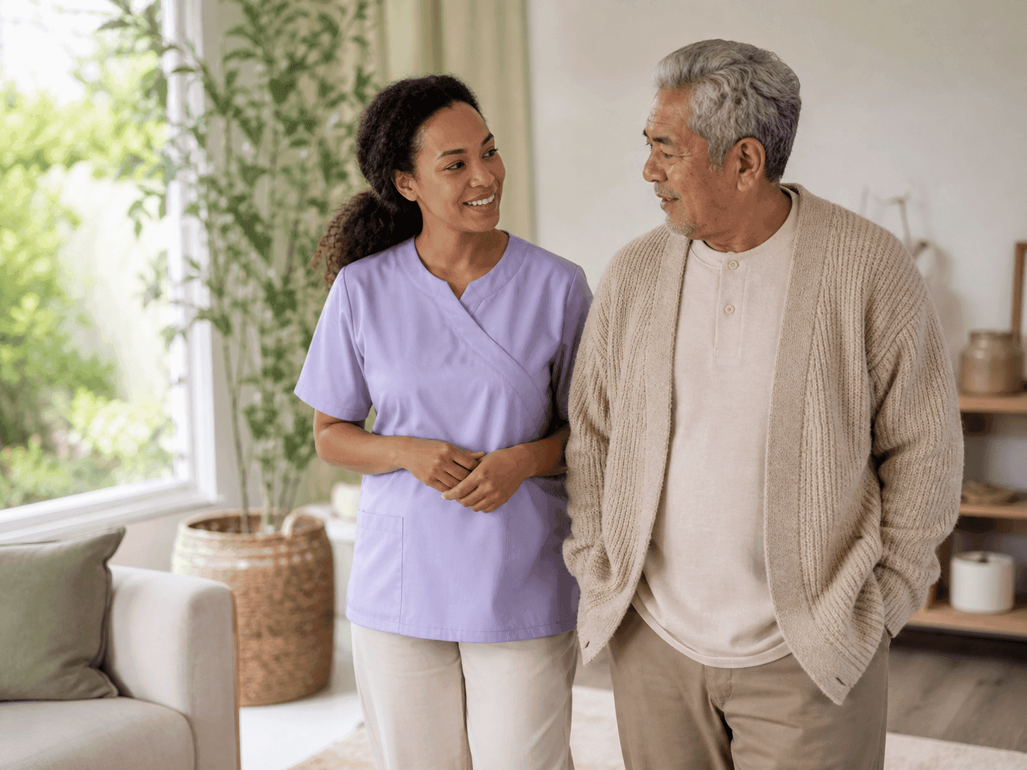 Professional caregiver listening attentively to an elderly client at home