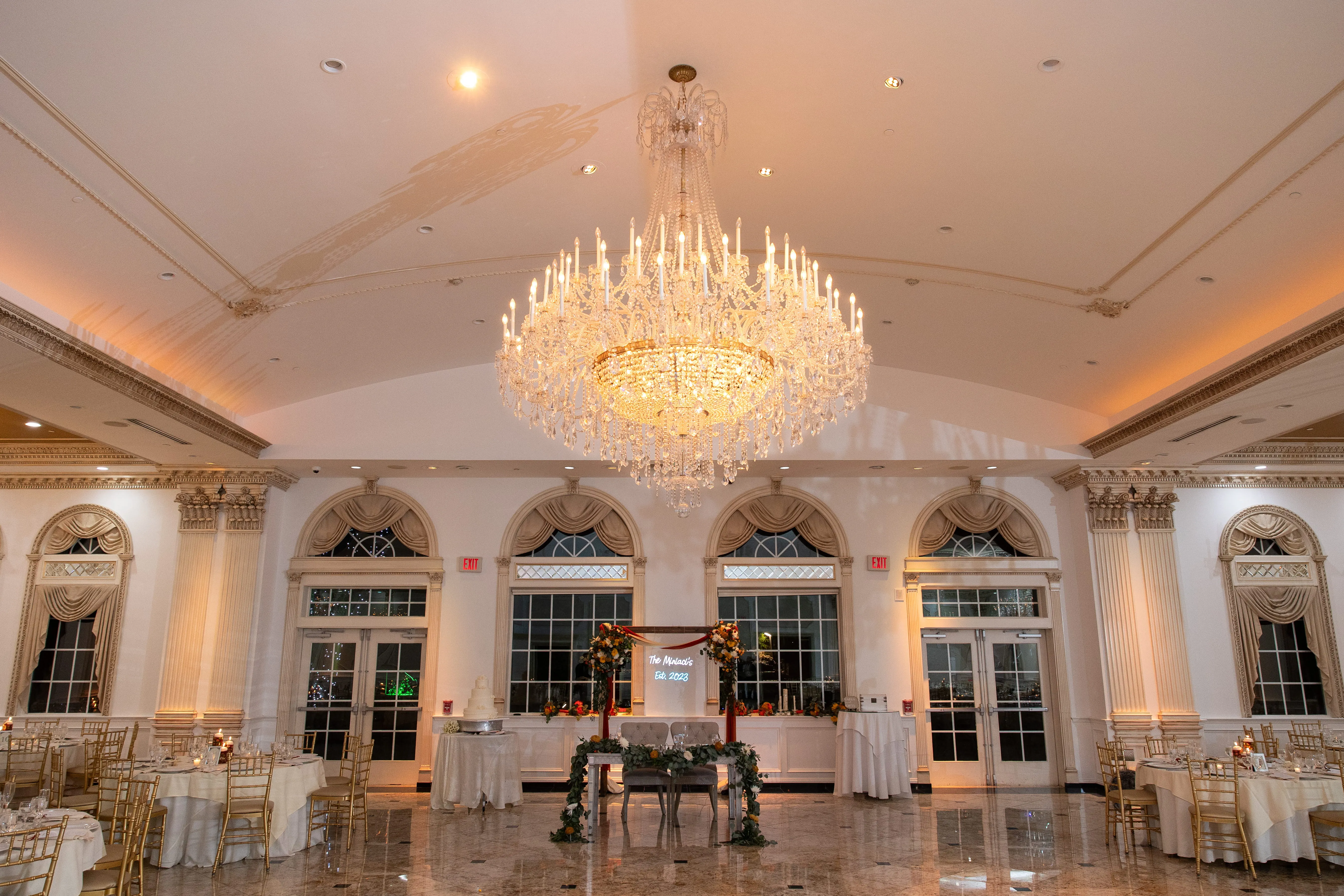 Wedding ceremony setup with floral arch and enhanced lighting design