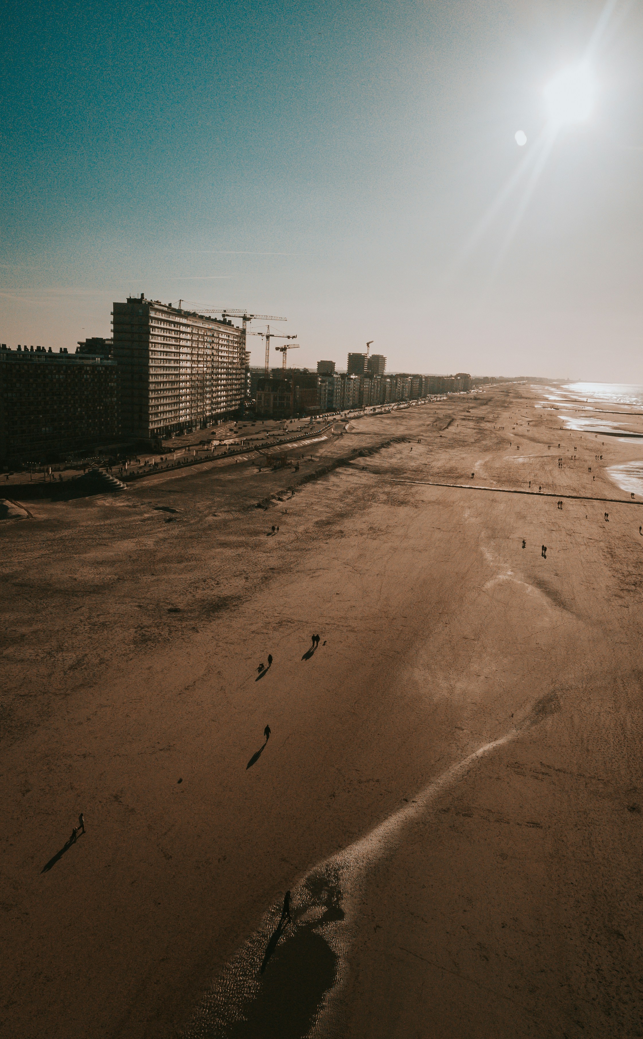 Close-up of a woman with under-eye gel patches, natural makeup, and smooth skin, against a neutral beige background
