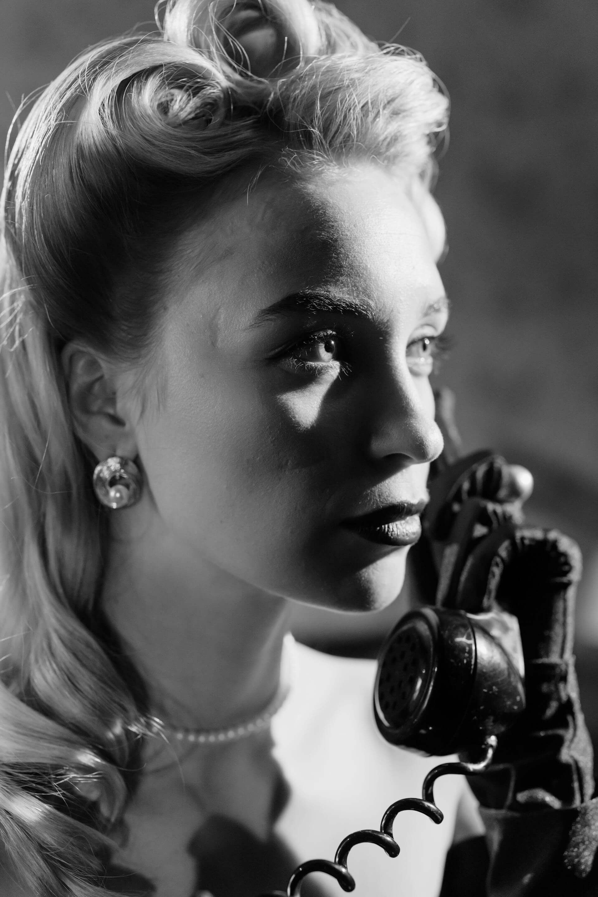 A woman engaged in a phone conversation, captured in a striking black and white image