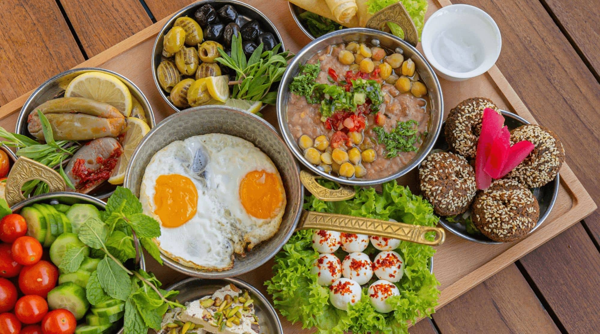 A breakfast place in Dubai with a Middle-Eastern platter with fried eggs, cucumbers, tomatoes, herbs and other breakfast staples. 