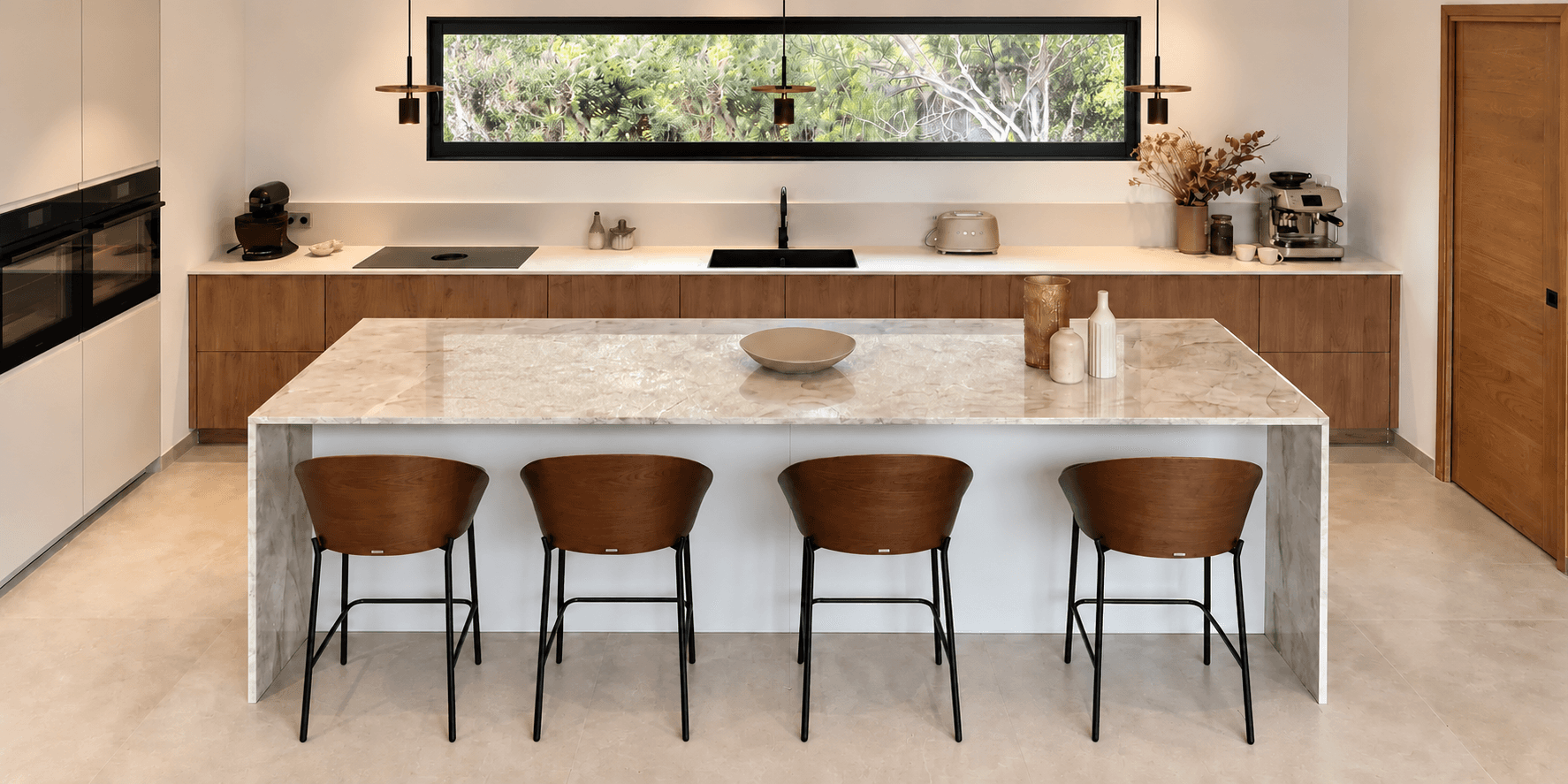Cuisine contemporaine réalisée à Corbara avec îlot central, façades bois brun cognac et plan de travail en pierre claire.