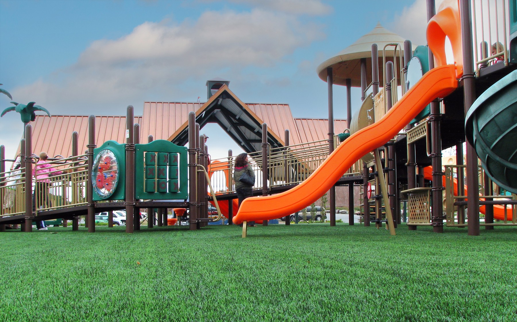 A lush green AGL Grass synthetic playground bathed in sunlight, perfect for picnics, play, or simply relaxing and enjoying nature.