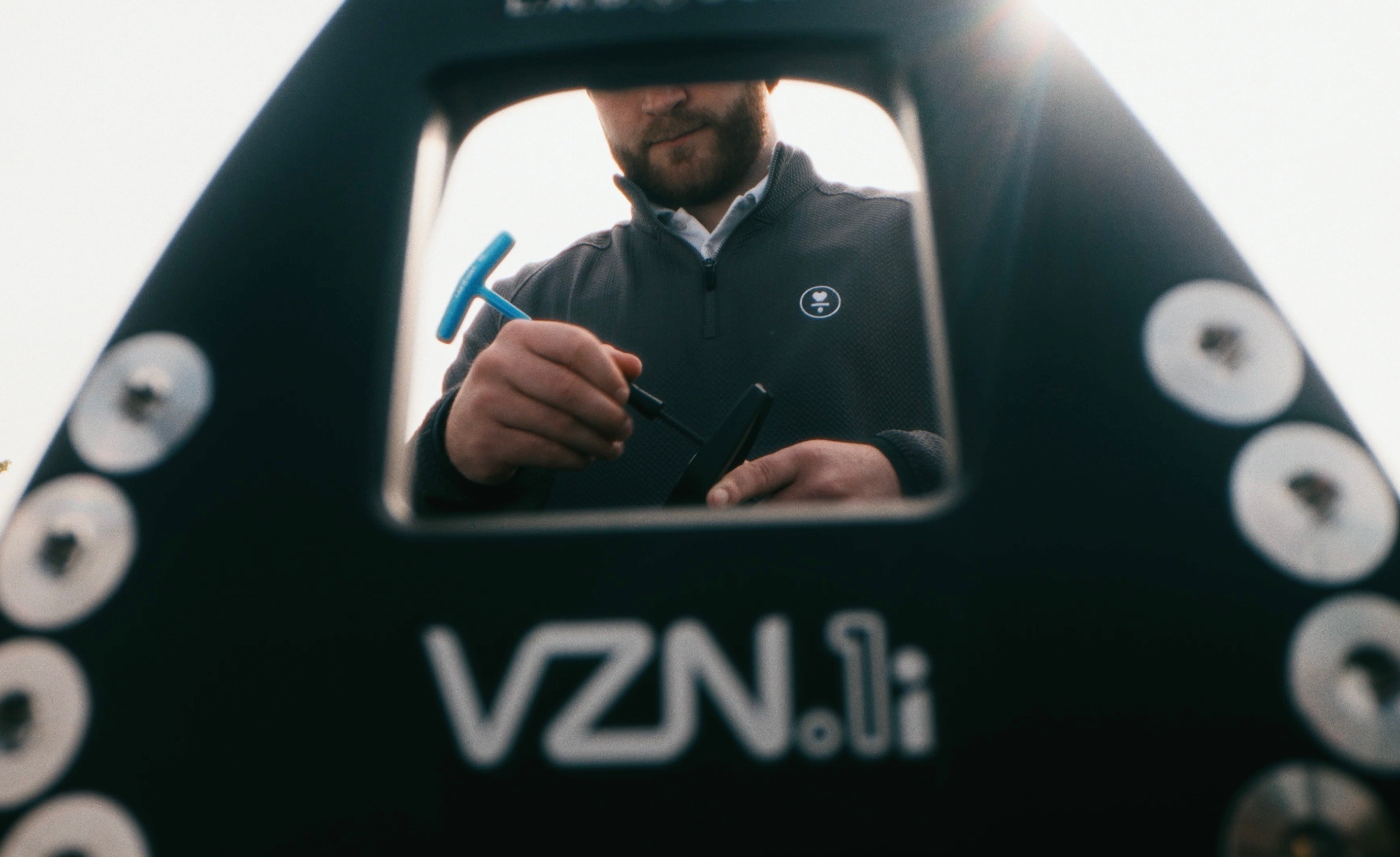 Man with lab putter, tighting screws on putter.