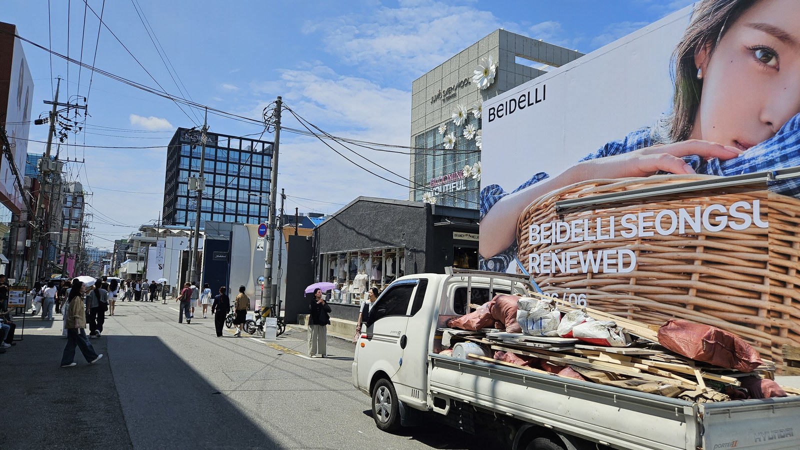 A daytime street in Seongsu-dong, Seoul, lined with low-rise storefronts and converted factory blocks.