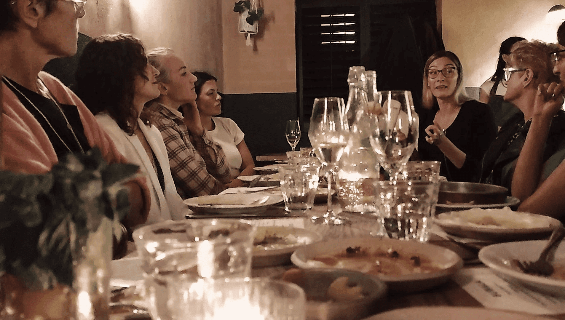 Group of women sitting around a long dinner table