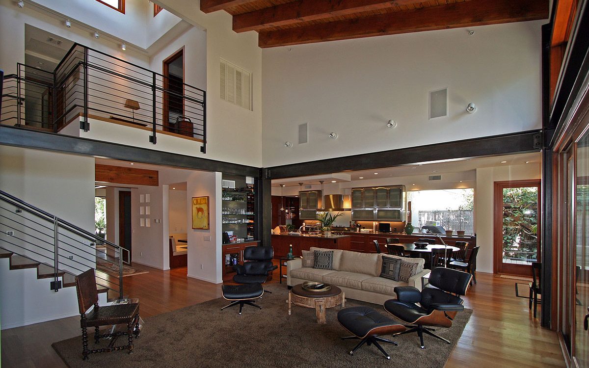 Interior living room showcasing exposed steel beams, blending industrial elements with natural light and open space.