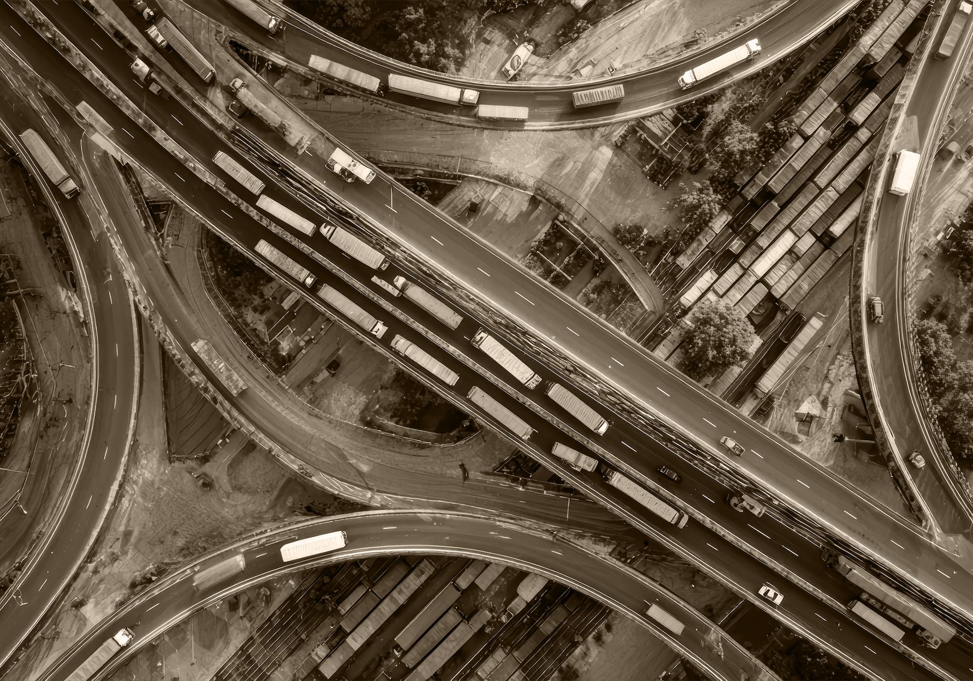 Aerial view of a busy highway interchange with multiple lanes of truck and vehicle traffic.