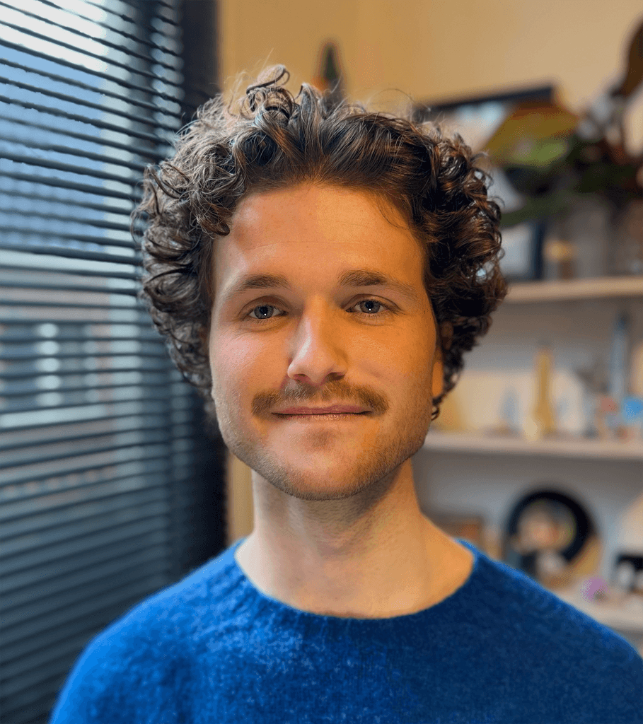 Portret van een jonge man met een blauw vest