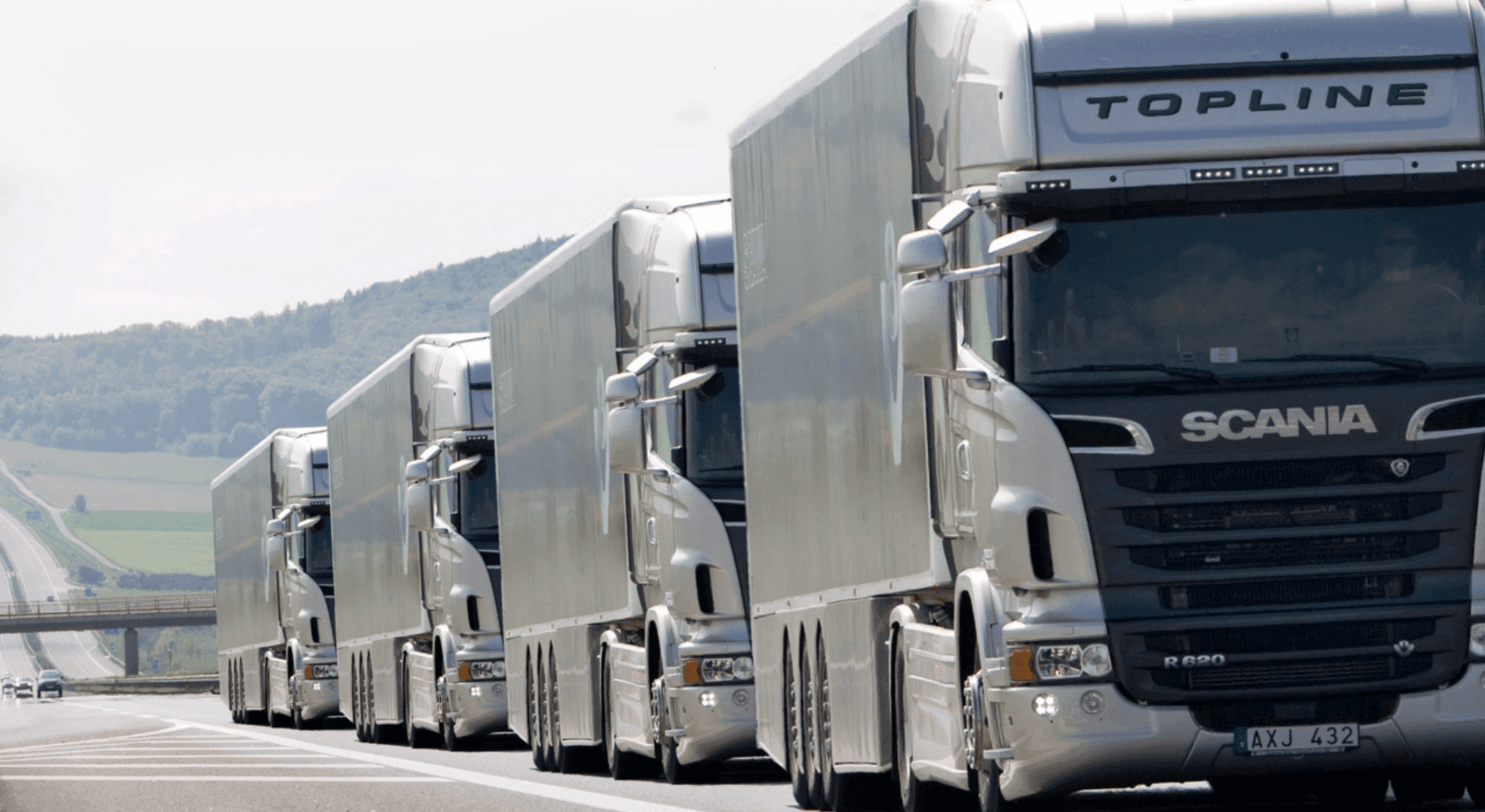 Haulage trucks in convoy on a night highway, symbolizing increased security to prevent moving truck robberies.