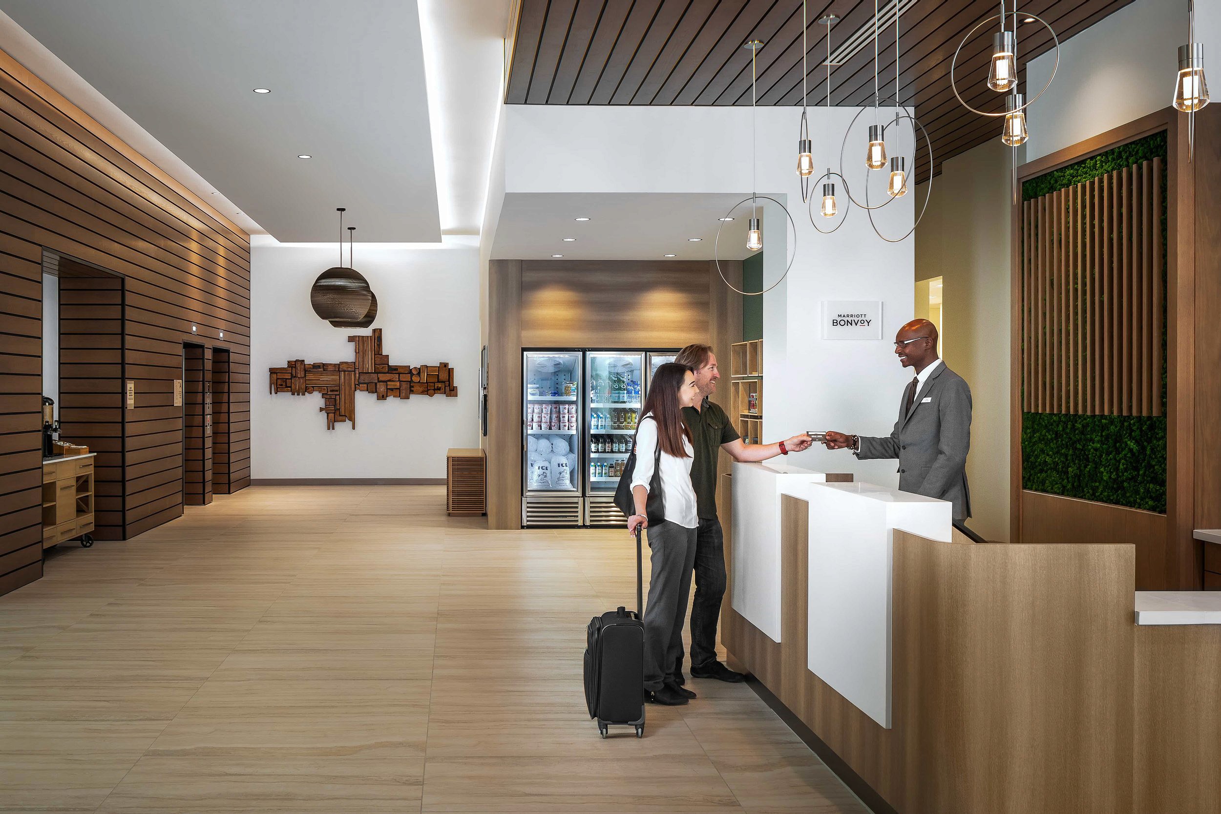 Couple checking in at hotel reception desk.