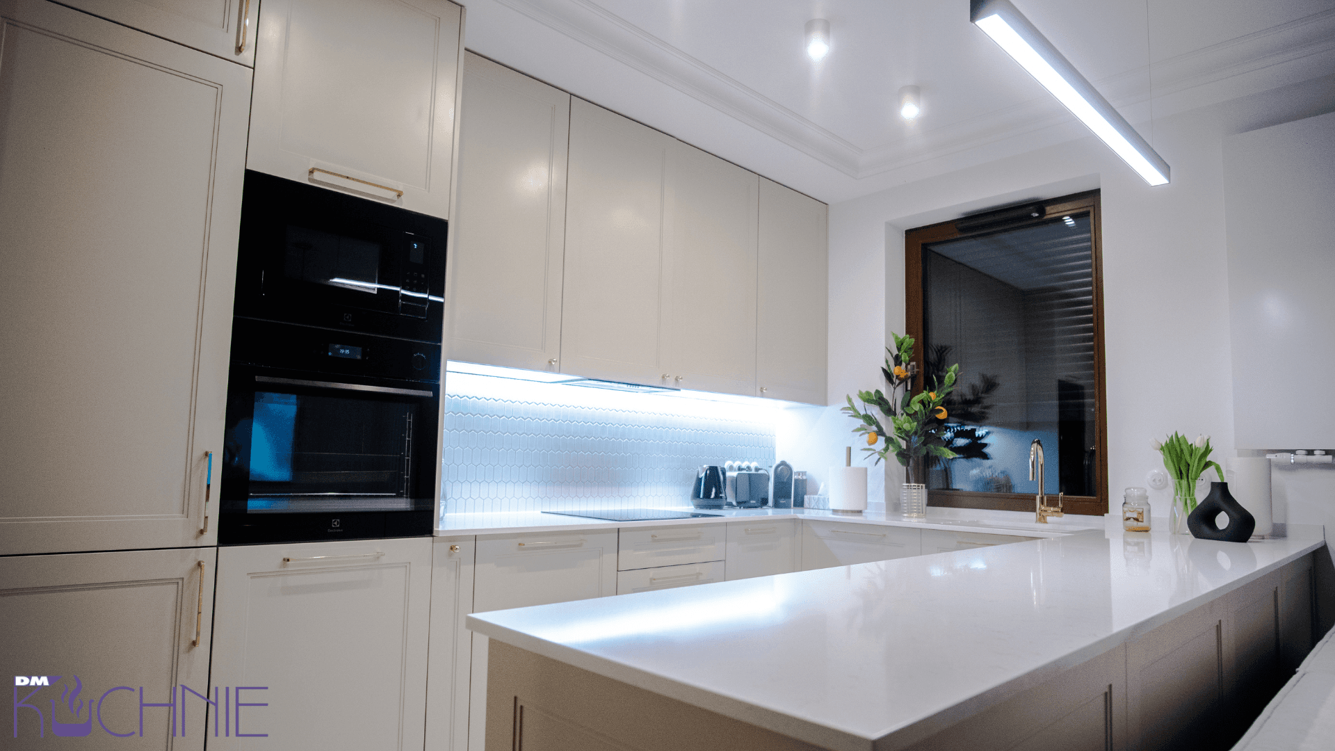 Meble kuchenne na wymiar w Warszawie – elegancka kuchnia z wyspą, jasna zabudowa pod sufit i podświetlenie LED