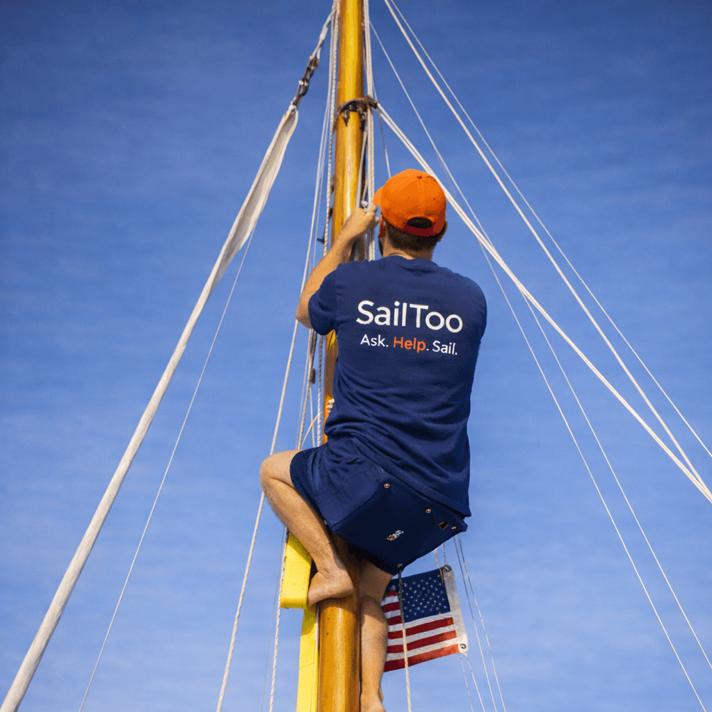 Marin qui porte un tee shirt SailToo et fait du bricolage sur un bateau