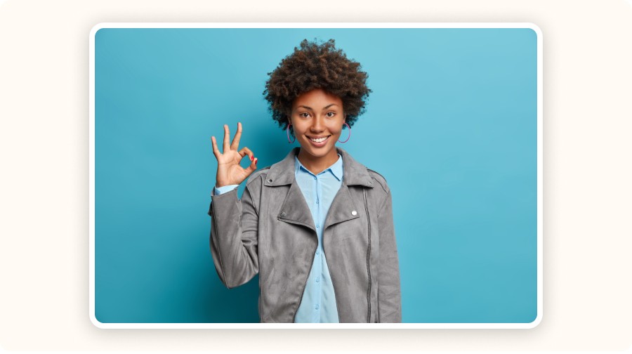 Jeune femme souriante faisant un signe "OK"