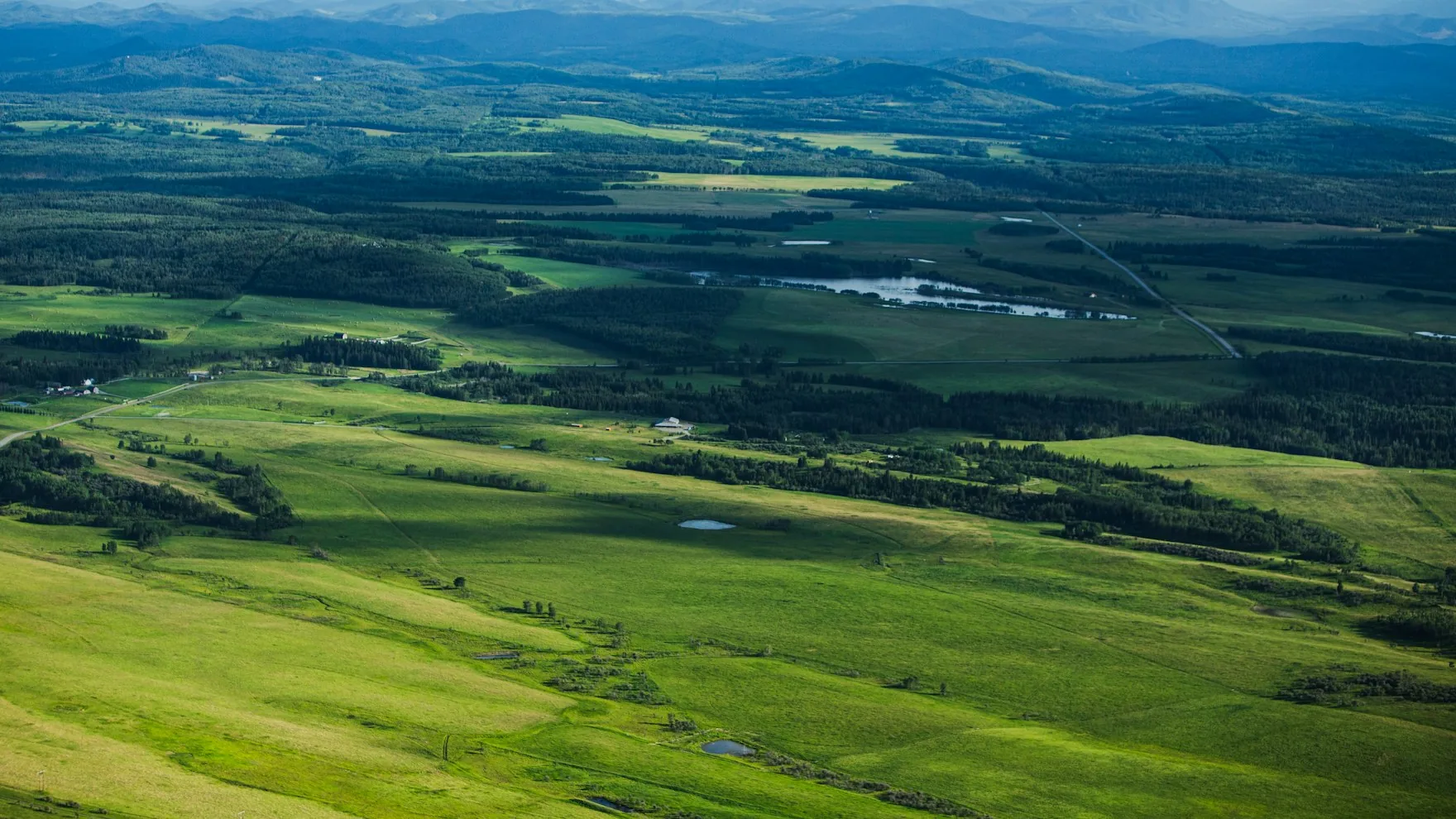 Green rolling foothills stretching to distant mountains