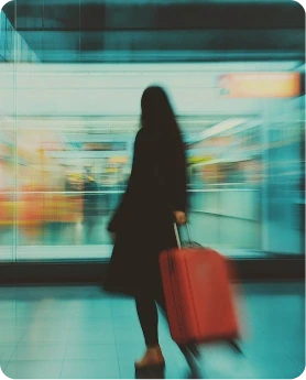 Blurred person with an orange suitcase at an airport