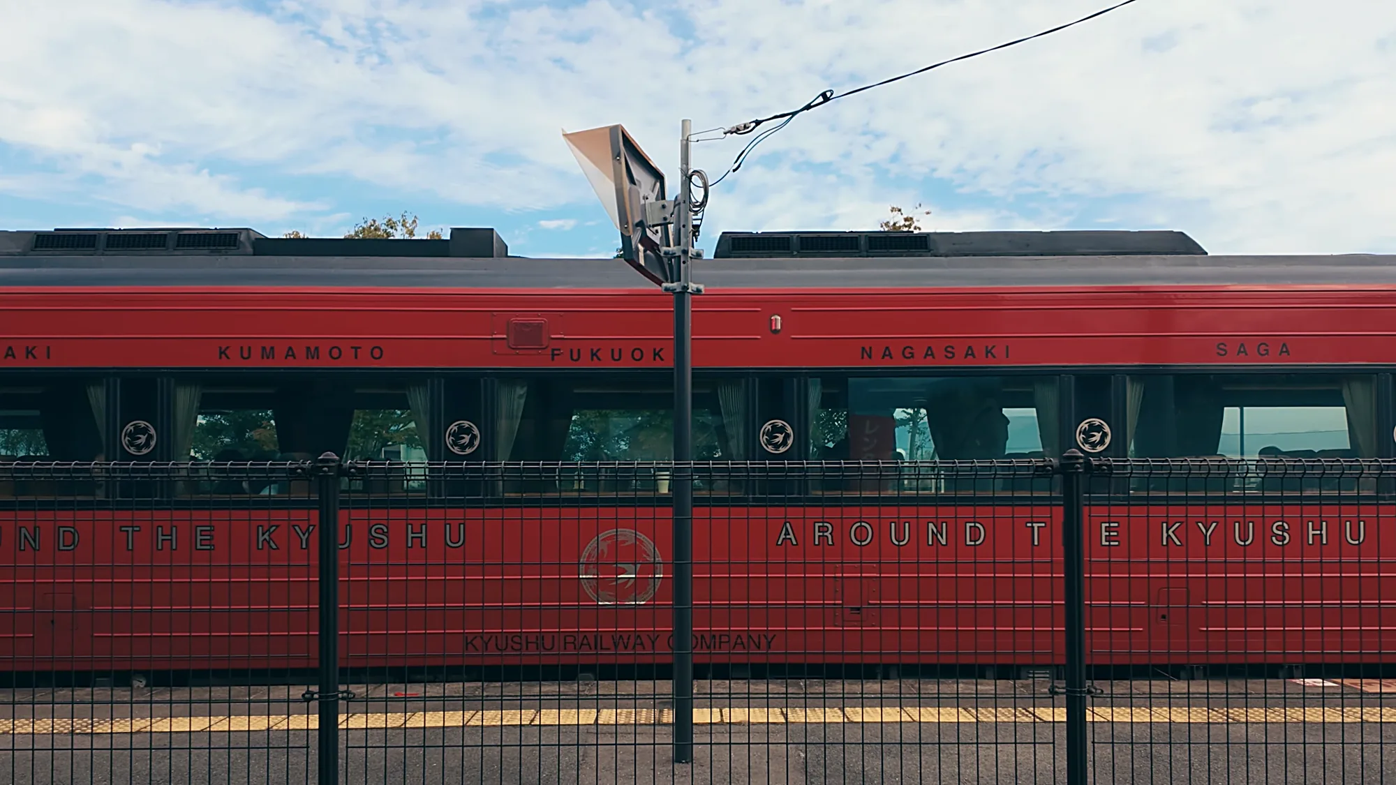 A red Kyushu Railway train marked for Kumamoto, Fukuoka, Nagasaki and Saga