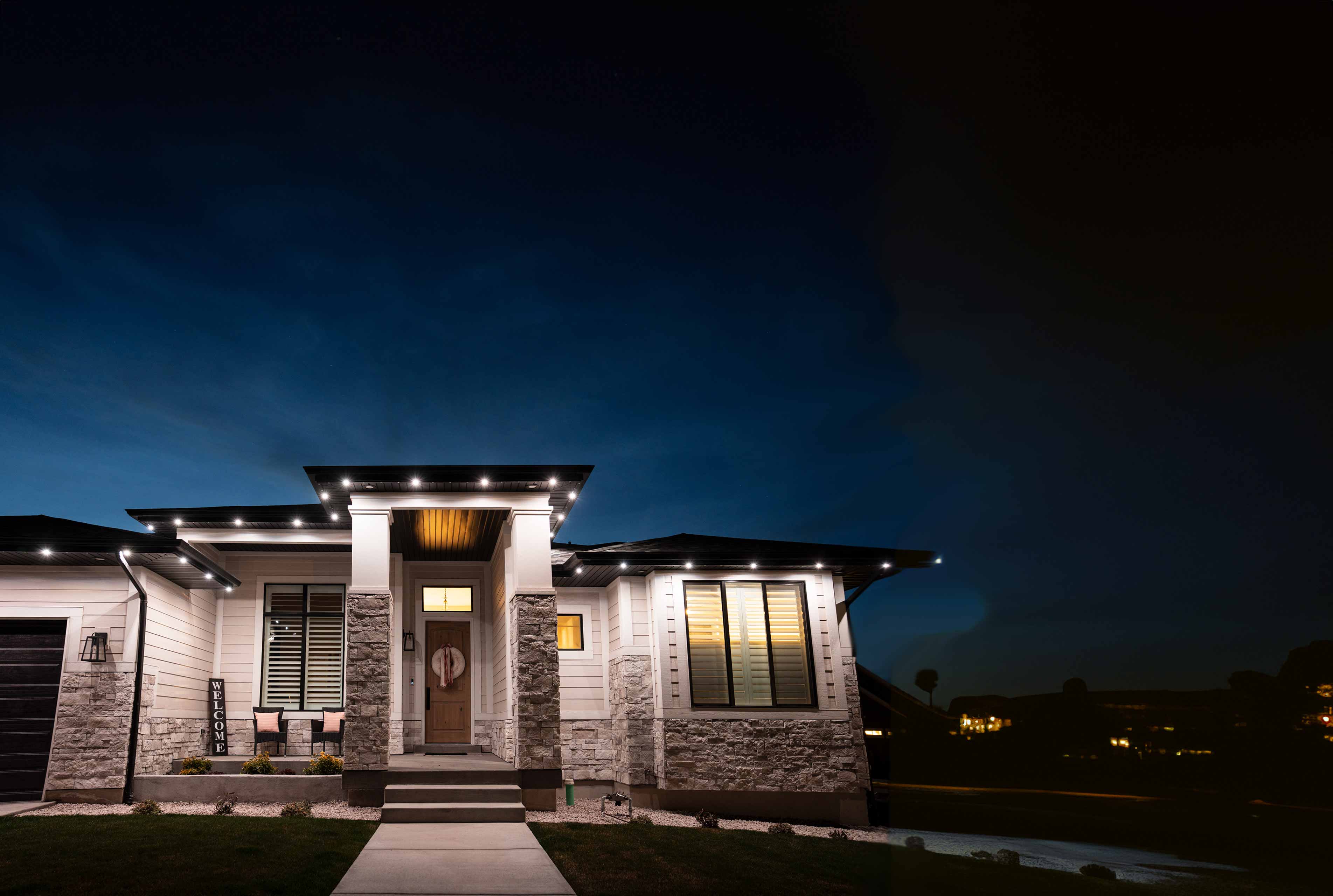 A house at night with white accent lighting going along the roof trim