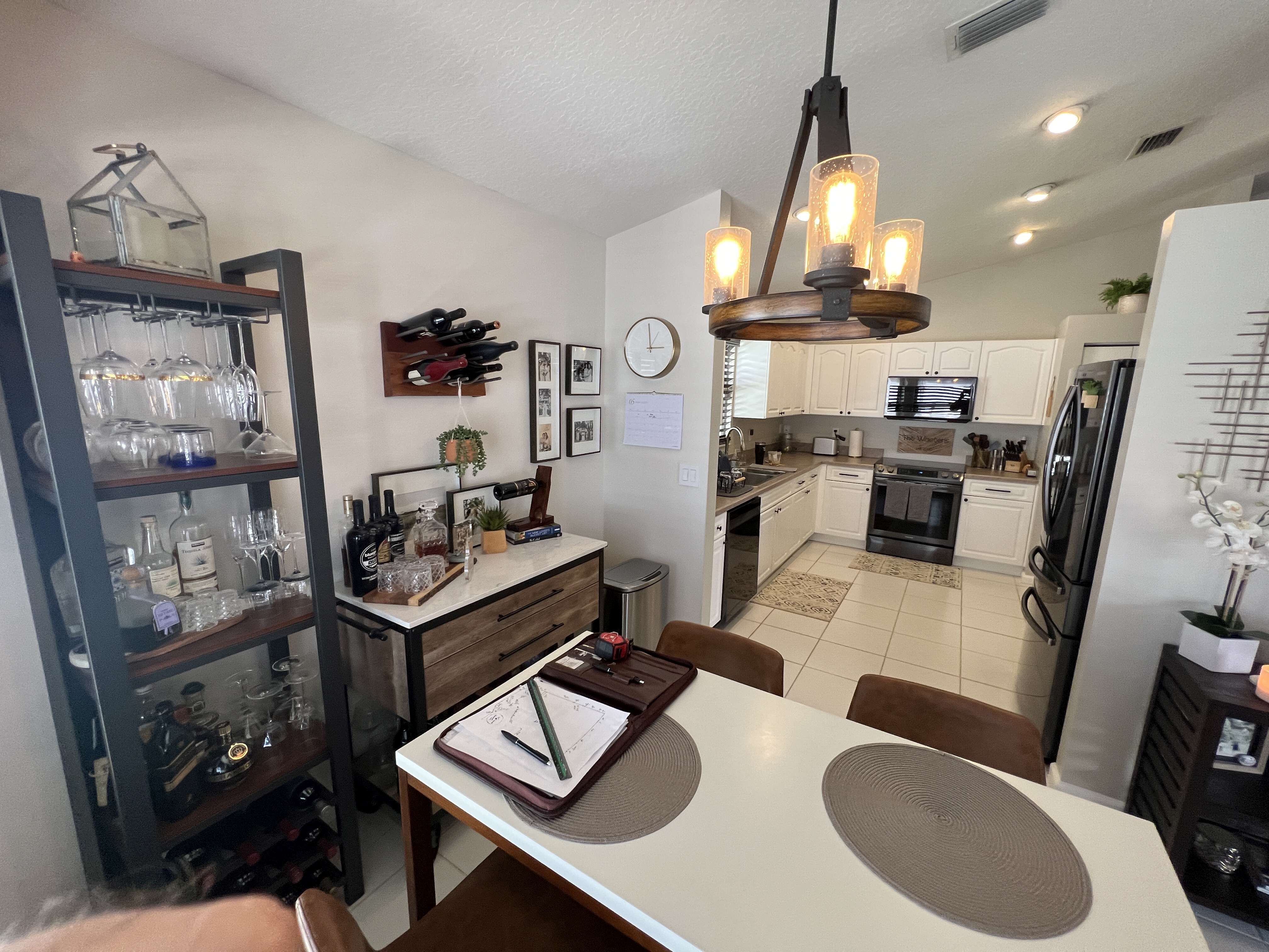 Old kitchen with white cabinets, countertops, and bar area.