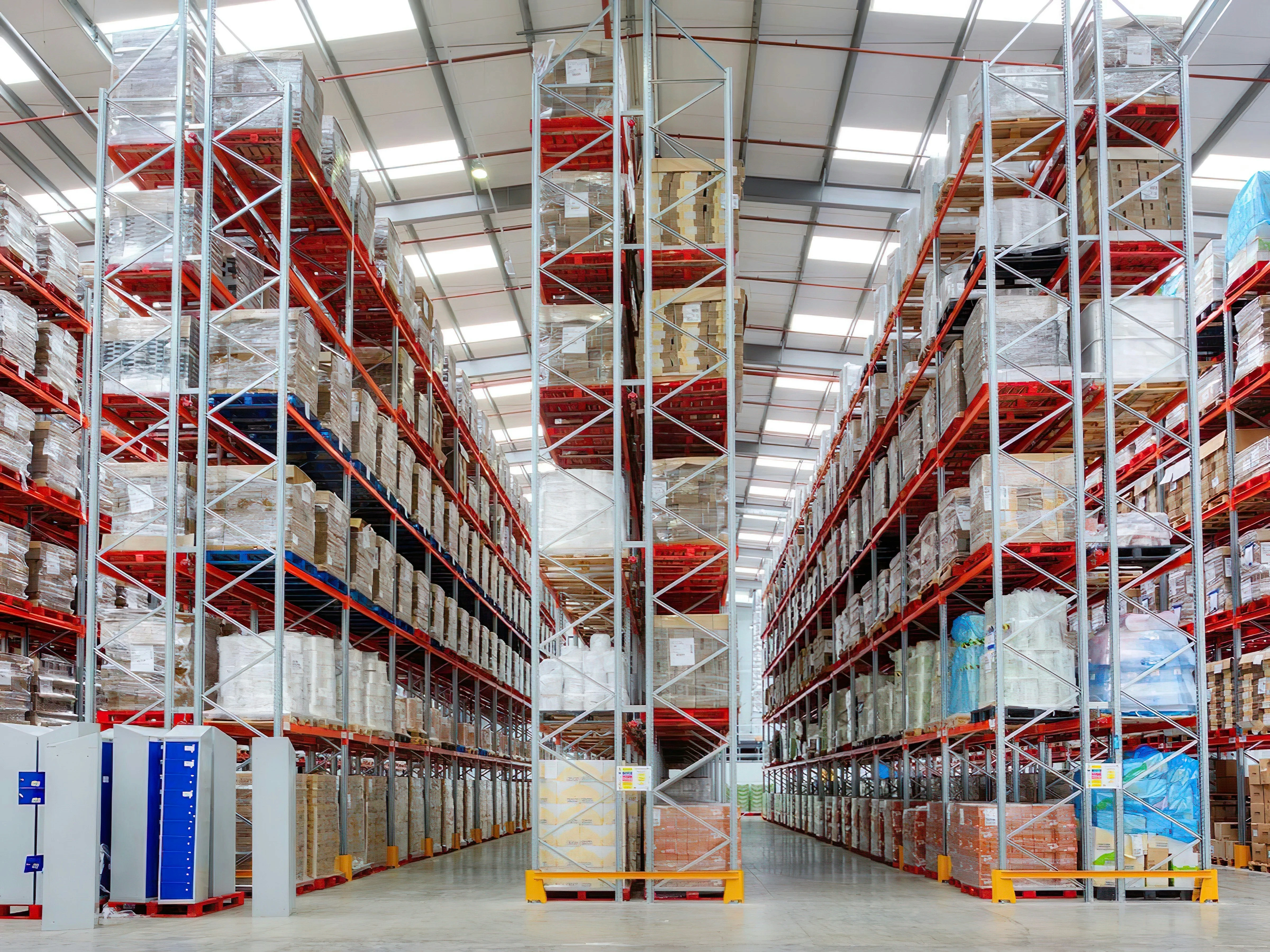 Warehouse aisles lined with tall pallet racks holding wrapped goods.
