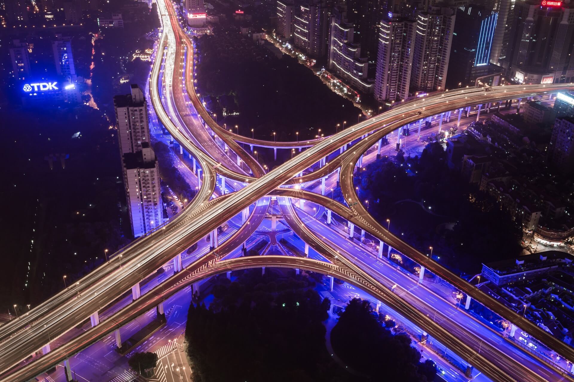 Overhead view of a futuristic and smart city with a main highway and a network of interconnected lanes.