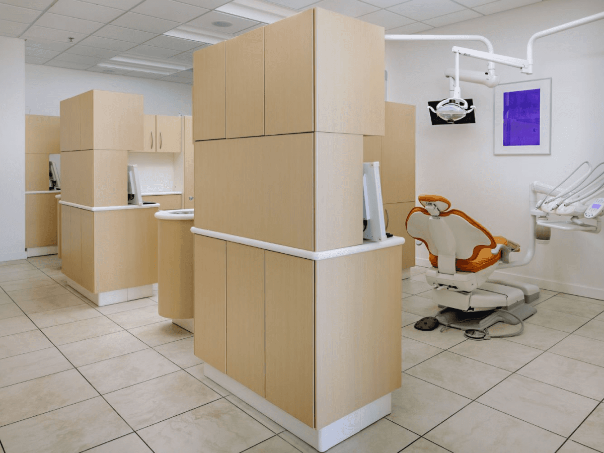 Dental treatment area with patient chairs and equipment in a modern setting.