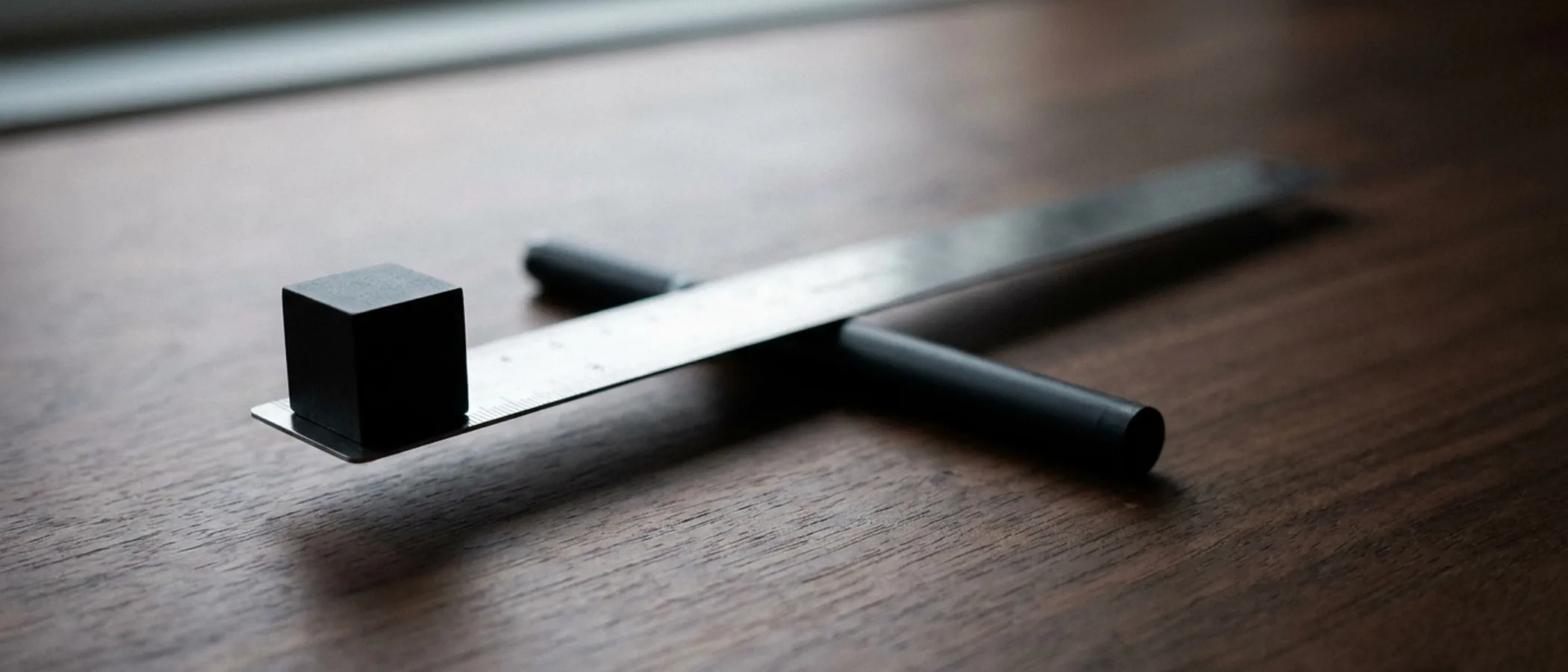 Black cube on a ruler with black handles