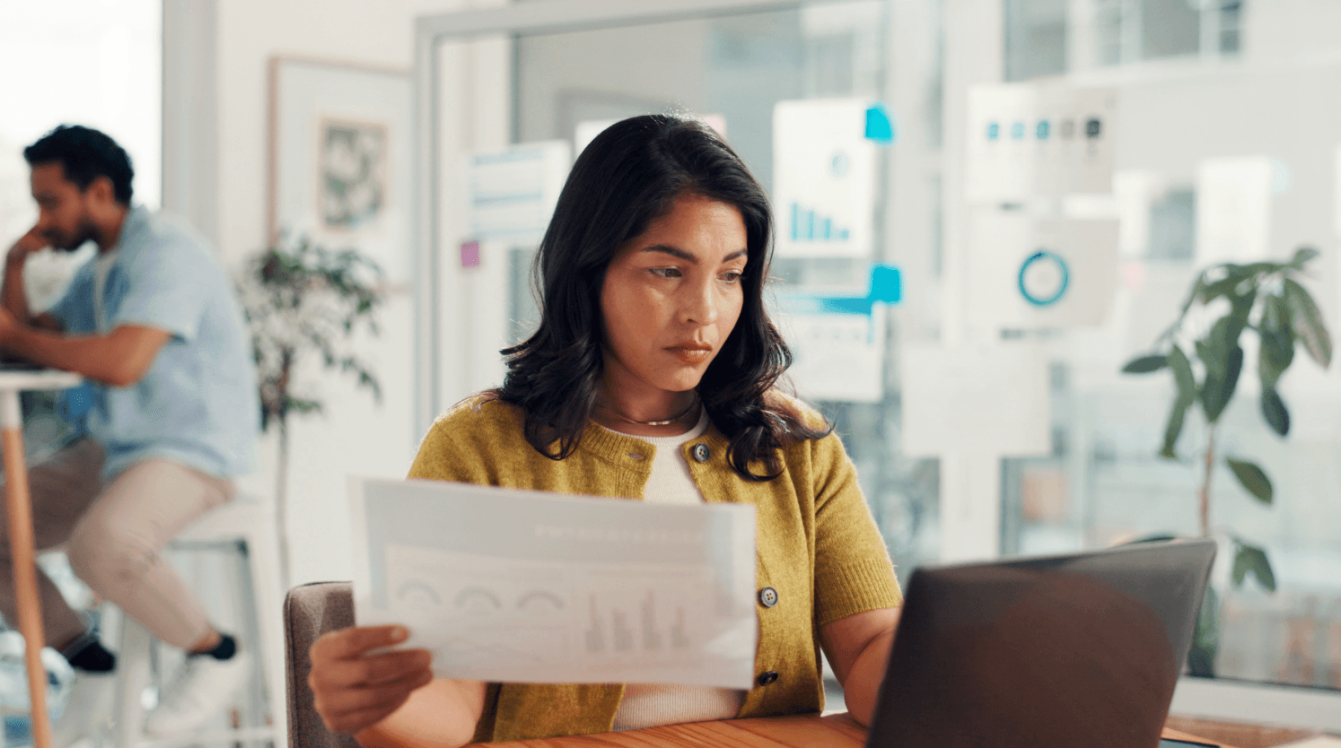 Woman analyzing marketing reports on a laptop, representing monitoring CPC changes and competitor activity in Amazon advertising auctions.