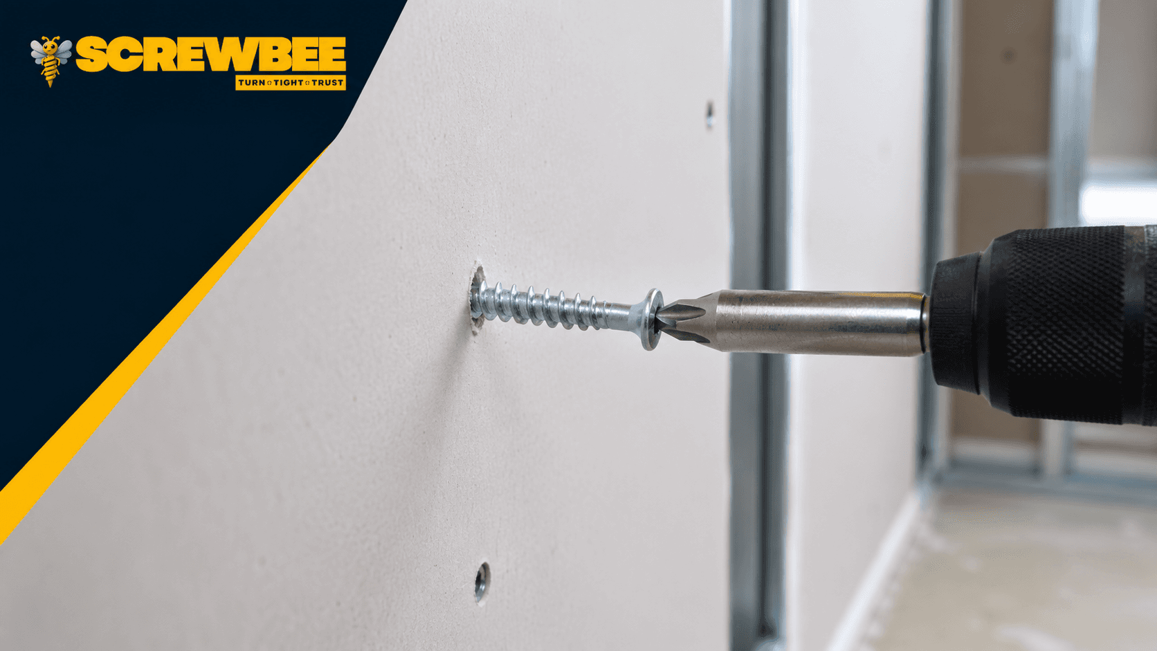 Close-up of a zinc drywall screw being installed into gypsum board with a drill