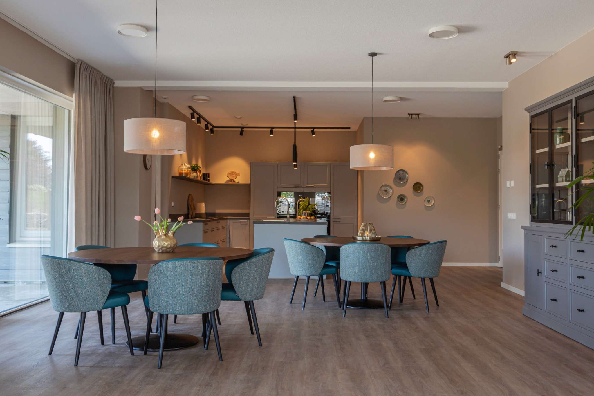 woonkeuken ouderenzorg woning blauwe stoelen, ronde tafels