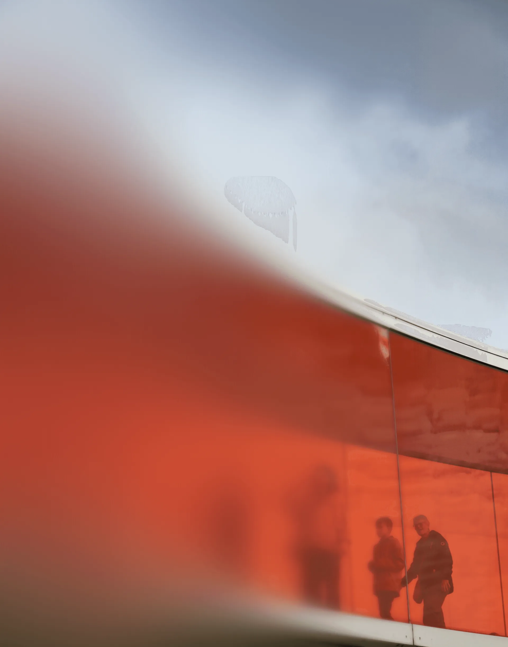 Silhouettes of people walking on a red walkway