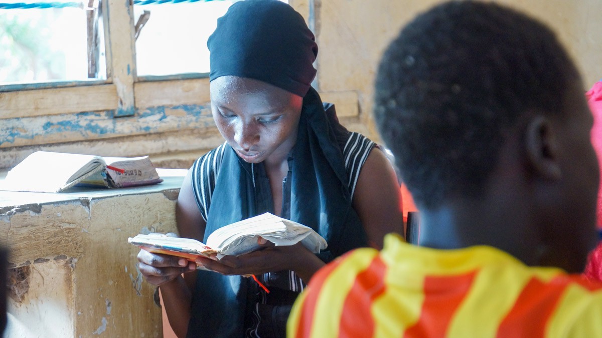 A girl reading here Bible during refugee youth camp